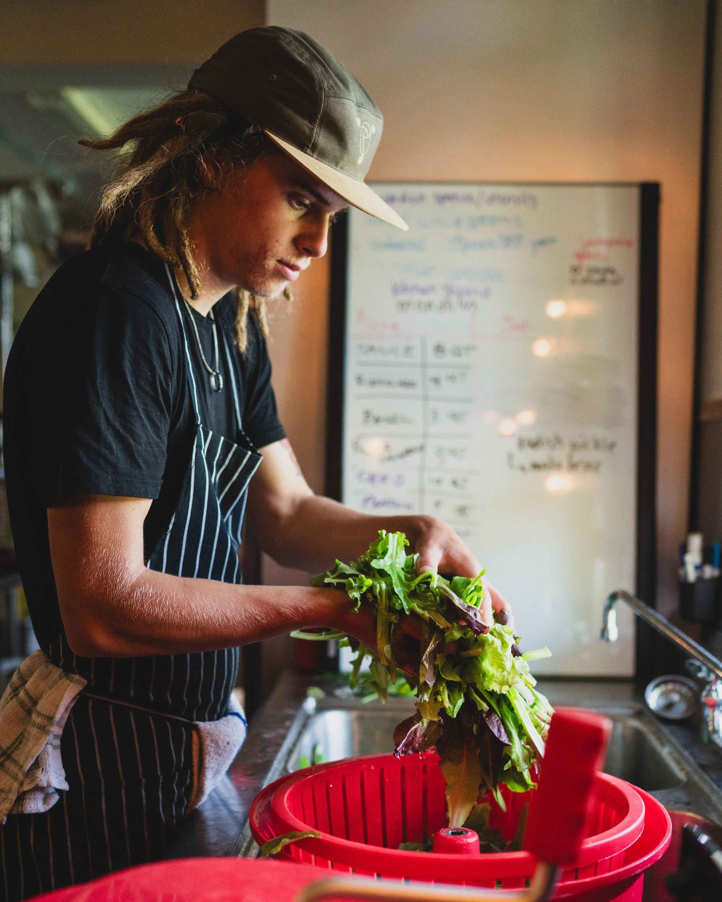 one of our chef interns washing salad greens
