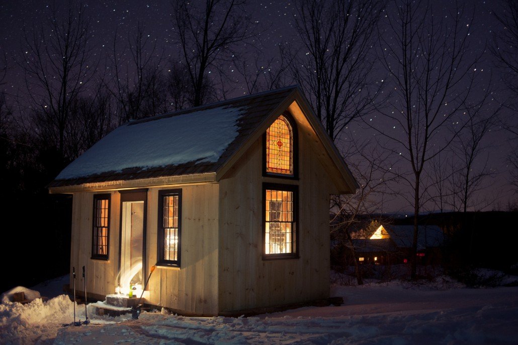 the cabin on our farm dusted in snow in the moonlight of winter, originally built for use in a film, that now houses interns and farm workers