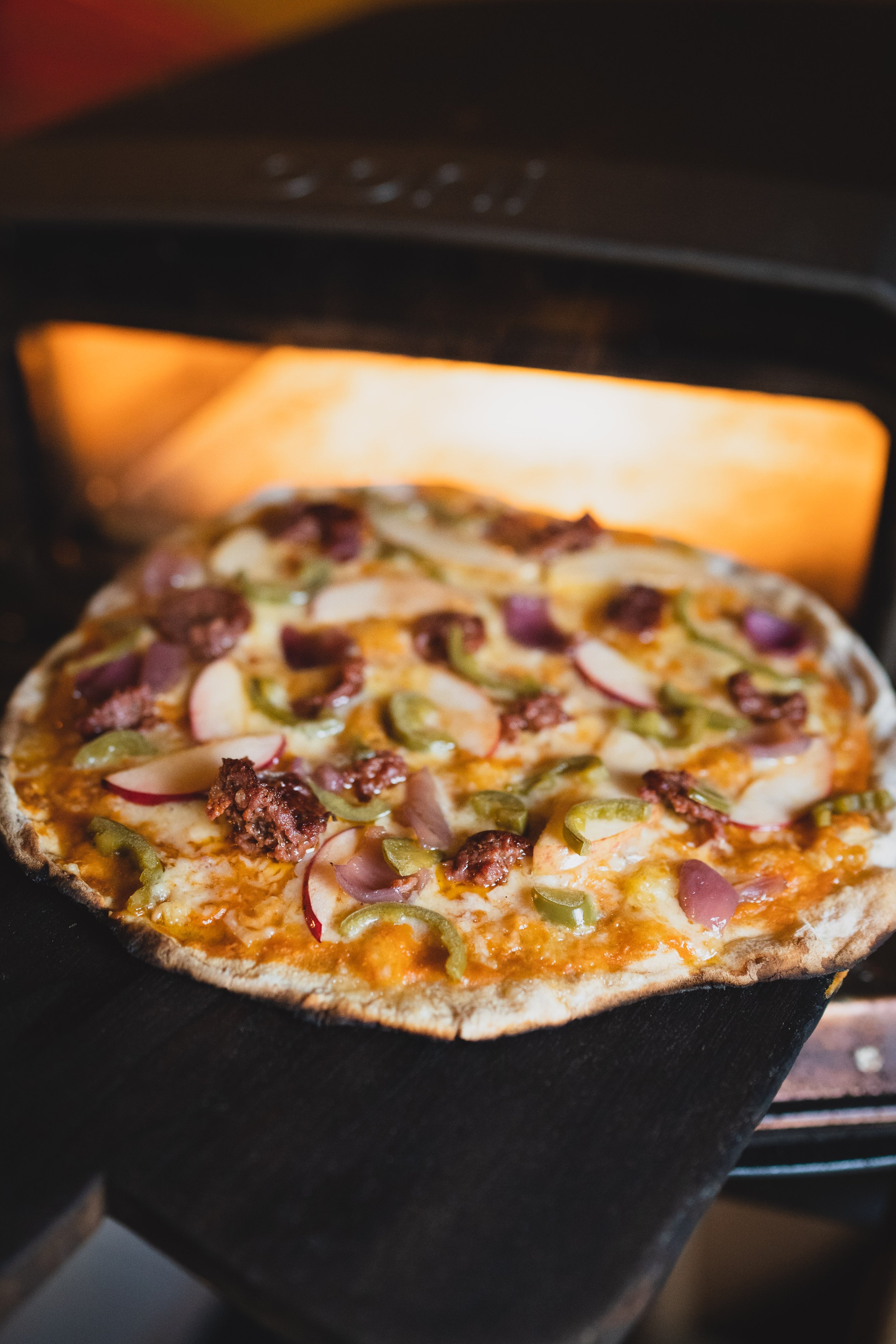 taking a pizza out of the oven 