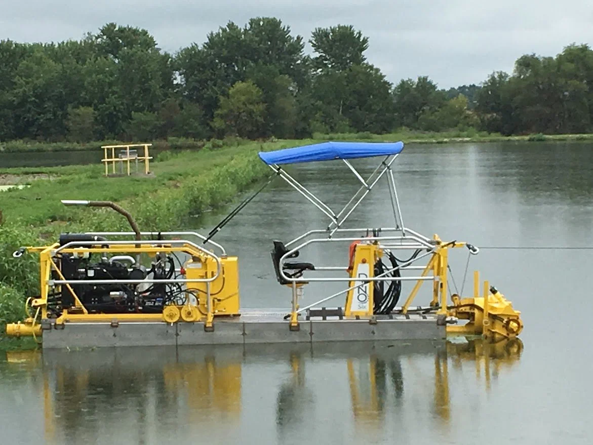 A yellow underwater drone with a blue canopy floating on a calm river, surrounded by green trees.