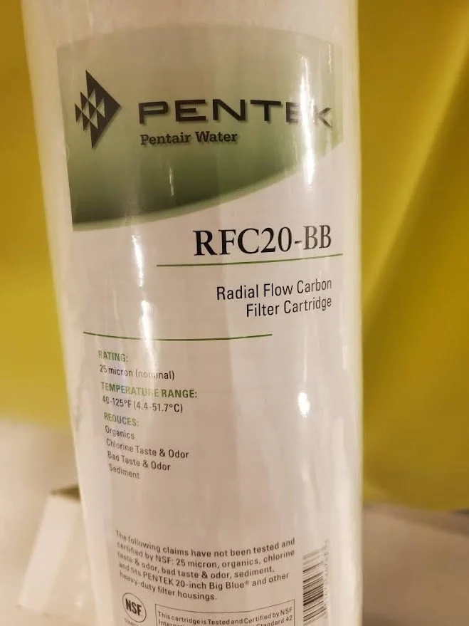 A white cylindrical water filter cartridge labeled PENTEK RFC20-BB Radial Flow Carbon Filter Cartridge with specifications printed on it.