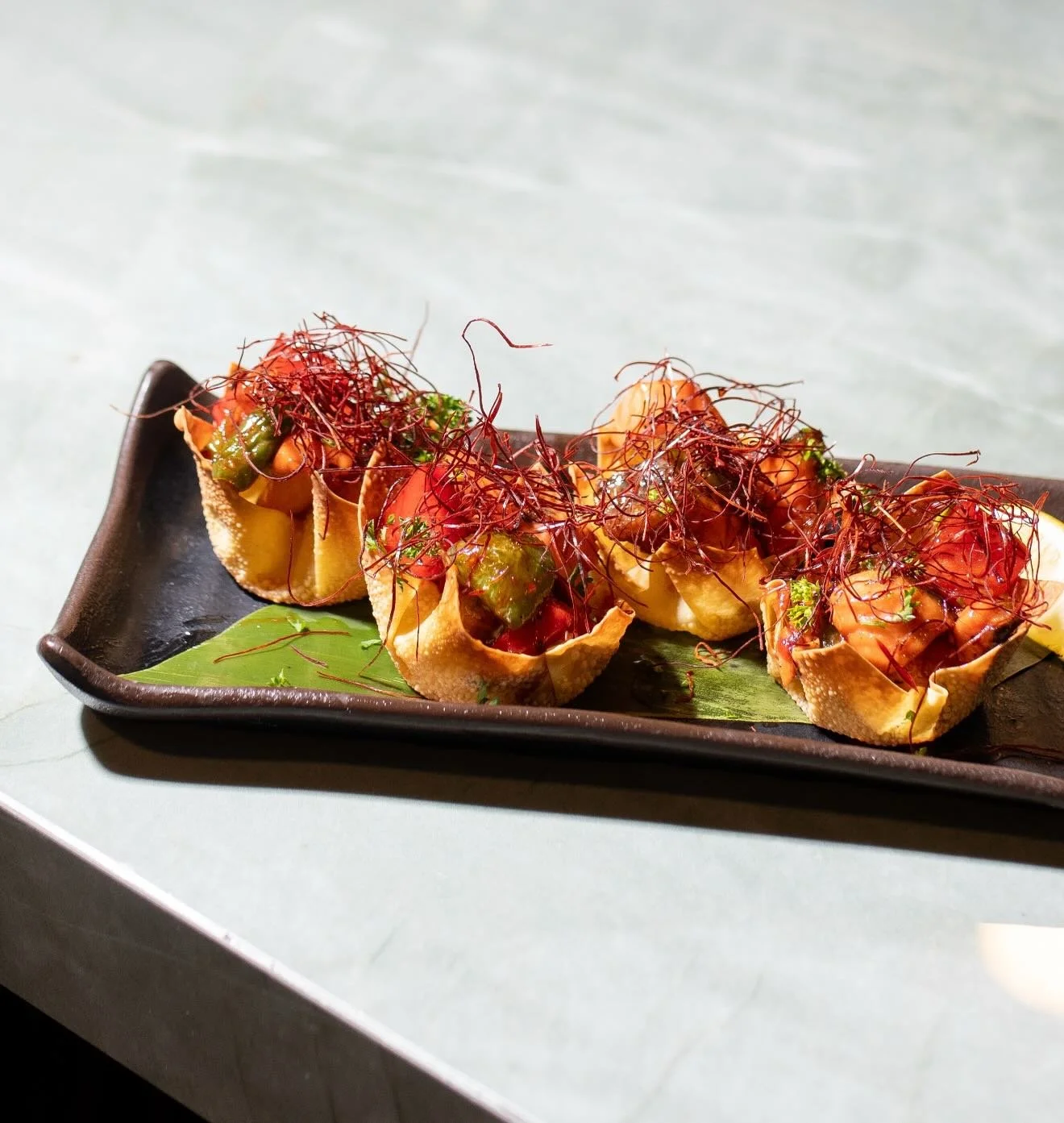 New dish alert 🚨 Our Salmon Wonton Cups are officially in the mix for the weekend, loaded with saut&eacute;ed salmon in spicy Pinoy mumbo sauce, plus peppers, onions, and chili threads. Fish Friday never looked this good.