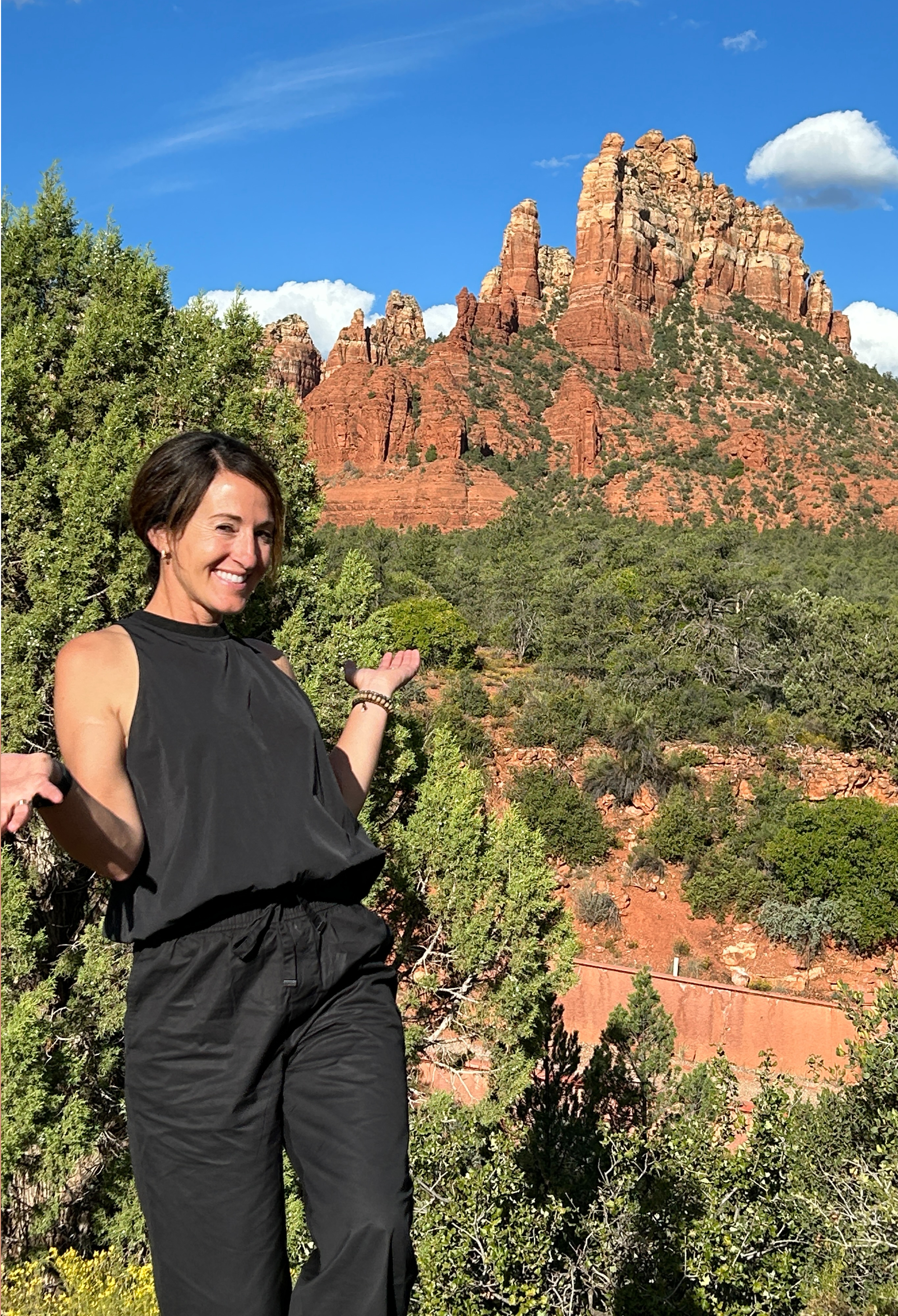Bideako founder, business consultant, educator and mentor smiles in front of the red rock cliffs in Sedona, Arizona.