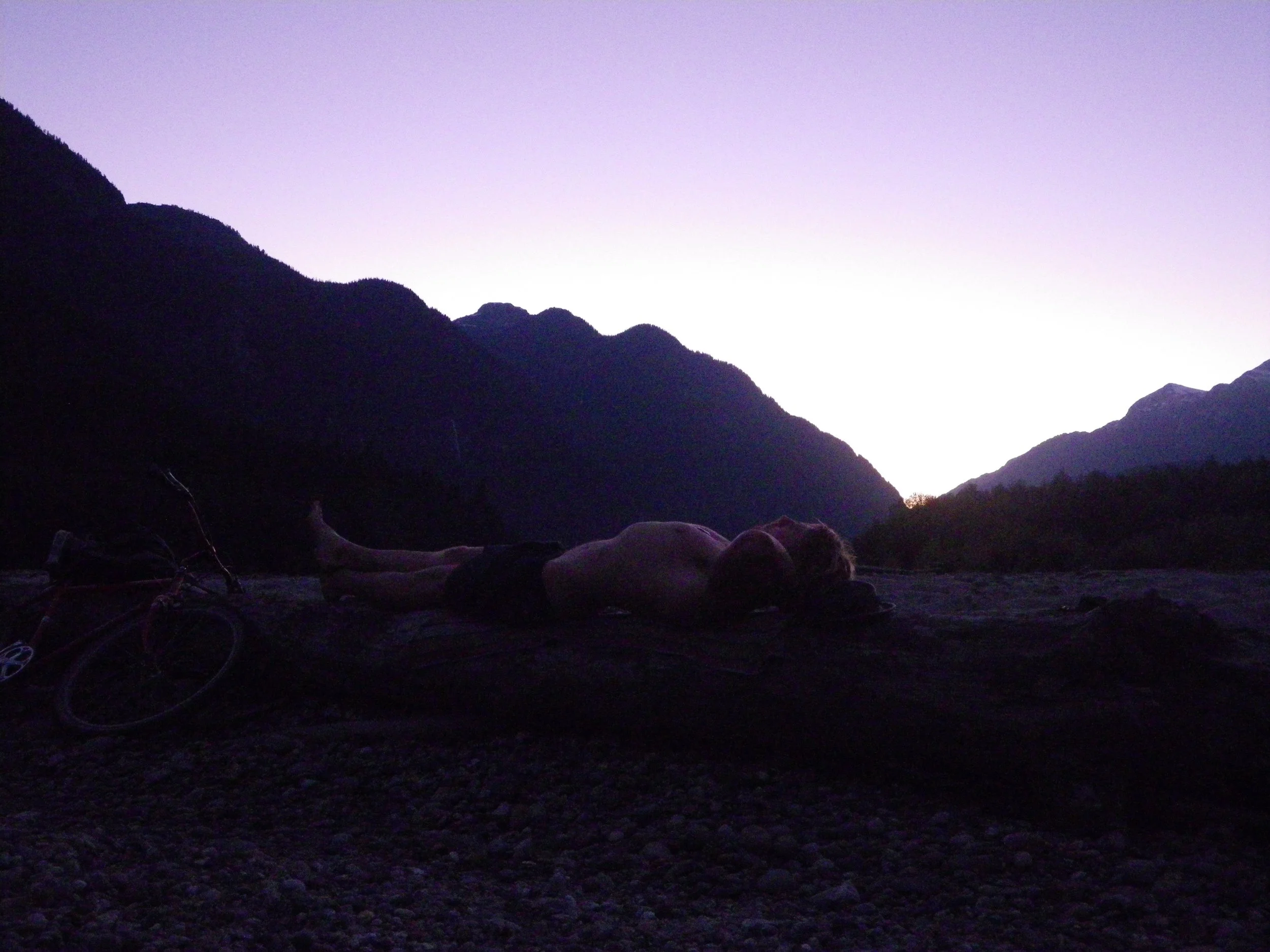 Tyler from Reading Nature laying in a mountainious valley as night falls.