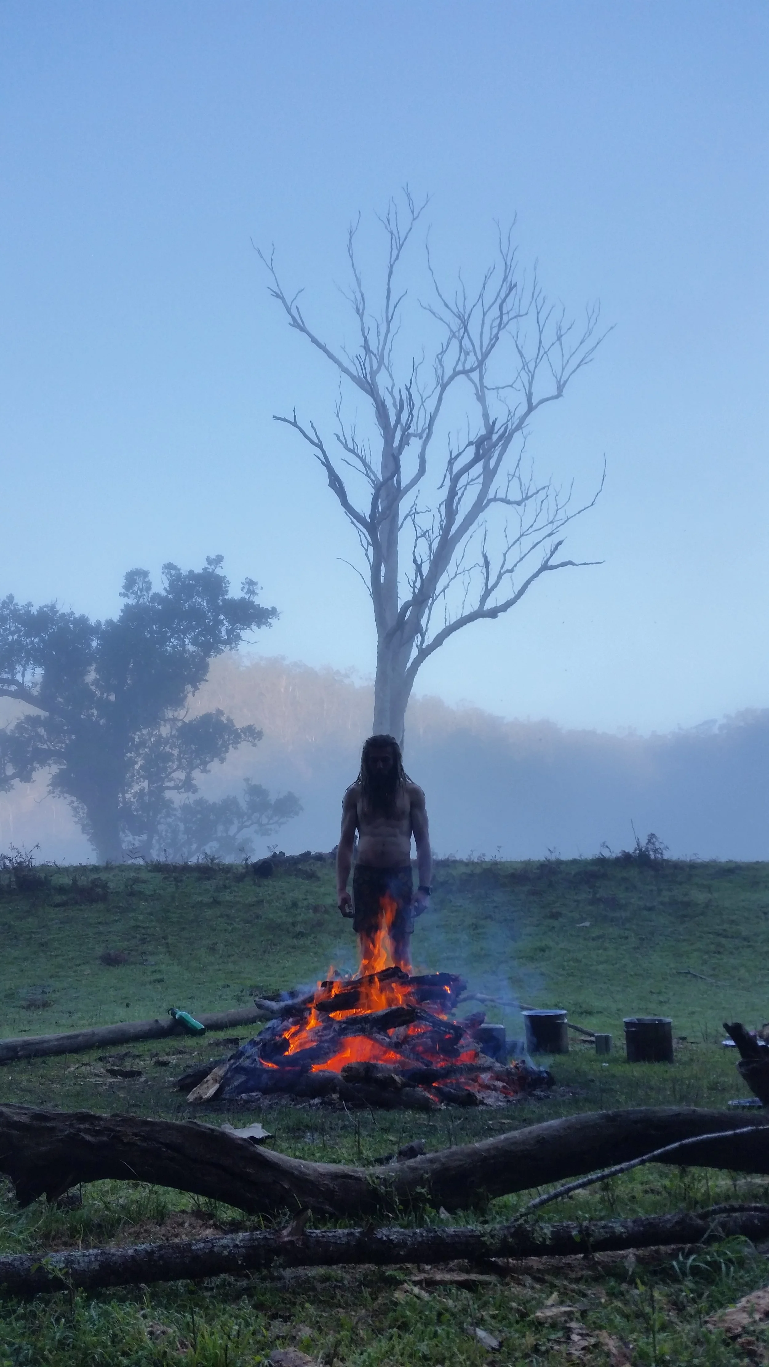 Tyler from Reading Nature, standing over a hand drill fire he lit at dawn