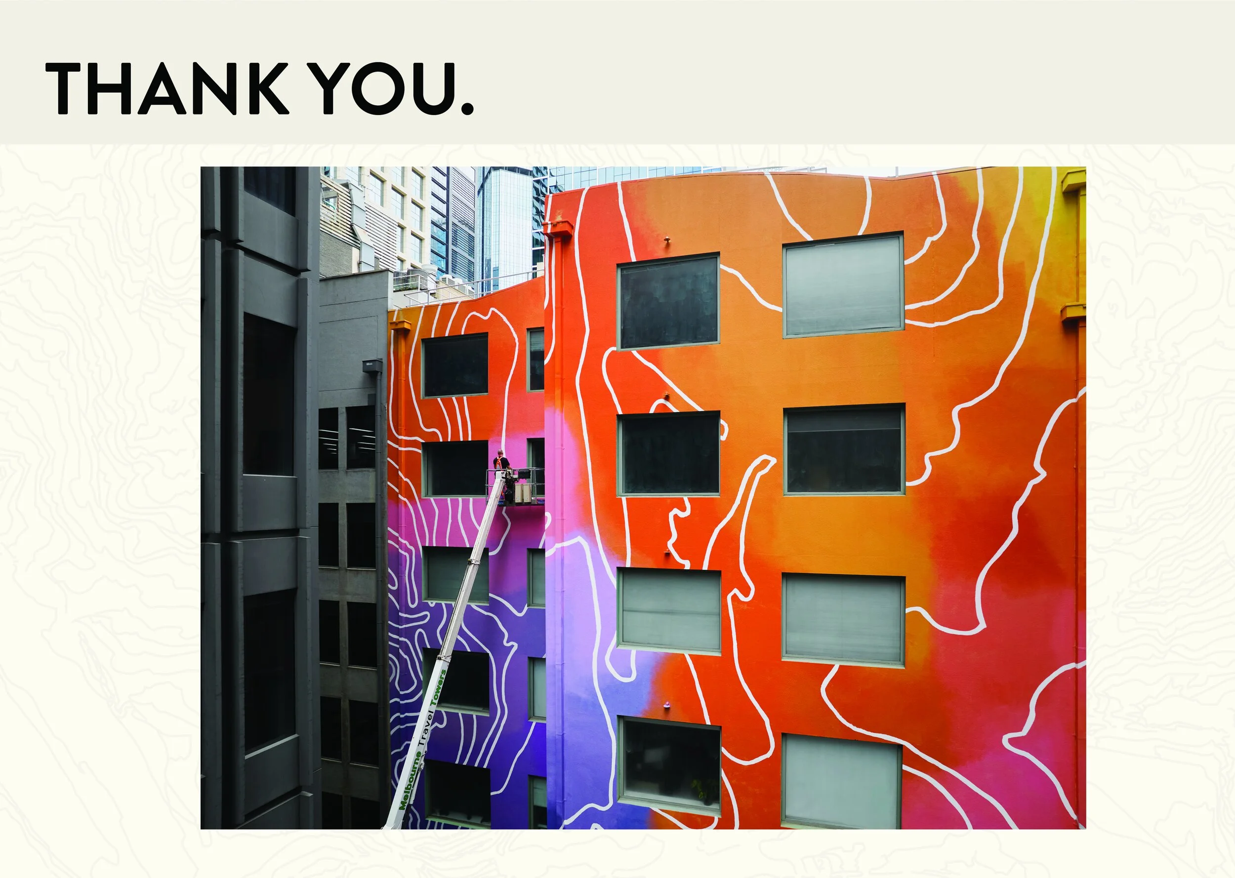 Colorful building with orange, pink, purple, and blue sections, featuring white contour line wall art and multiple windows, with a worker on a lift painting on the building