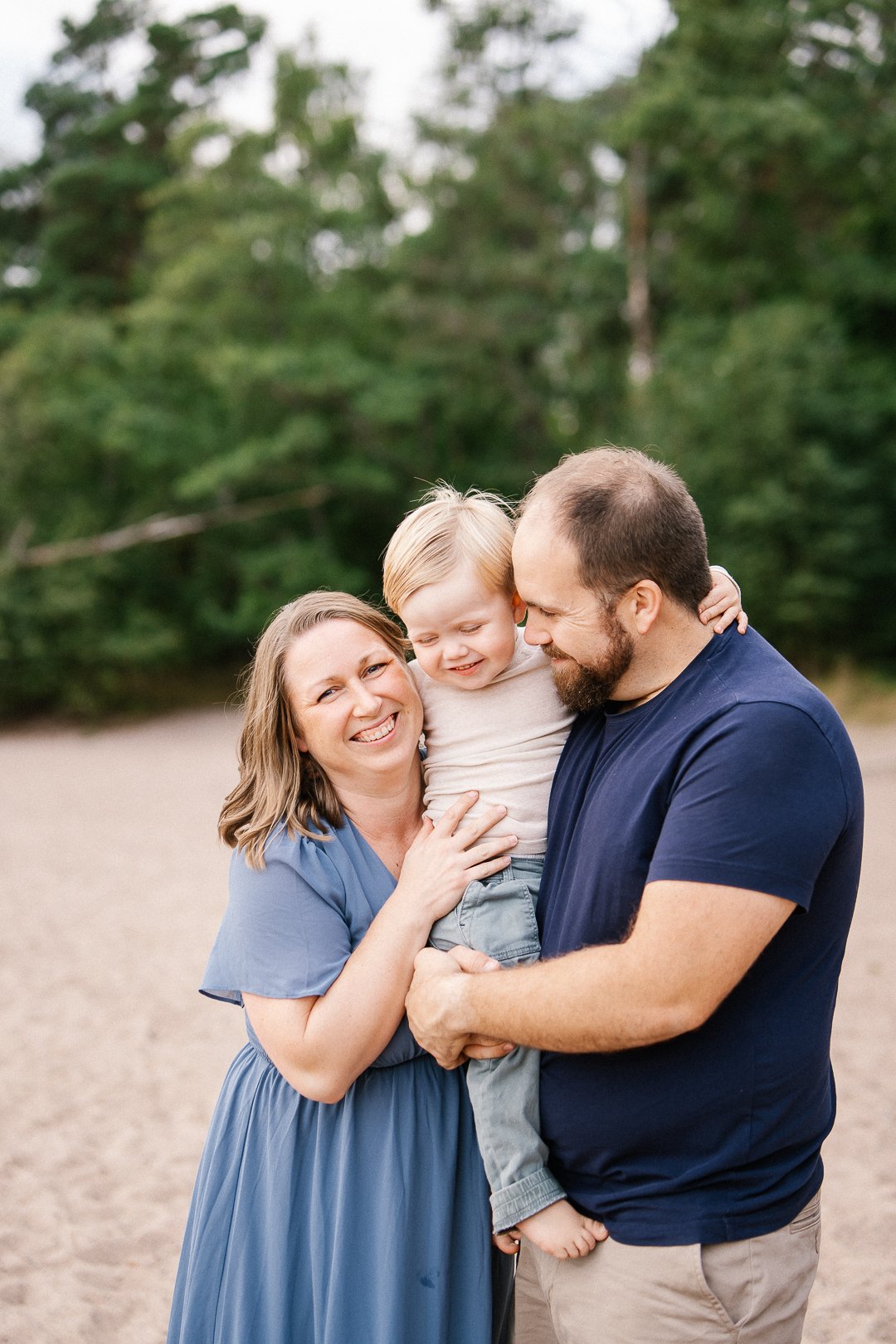 Perhe iloisesti halailee toisiaan luonnon keskellä.