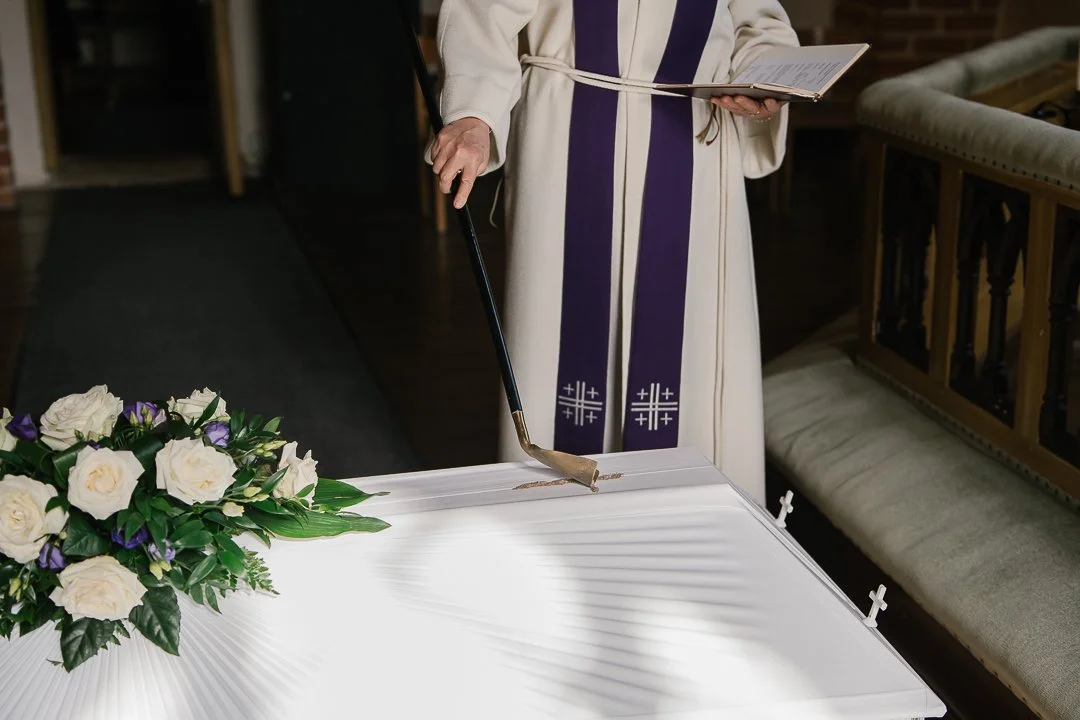 Pappi kastaa hiekkaa kirkkotekstiileihin.