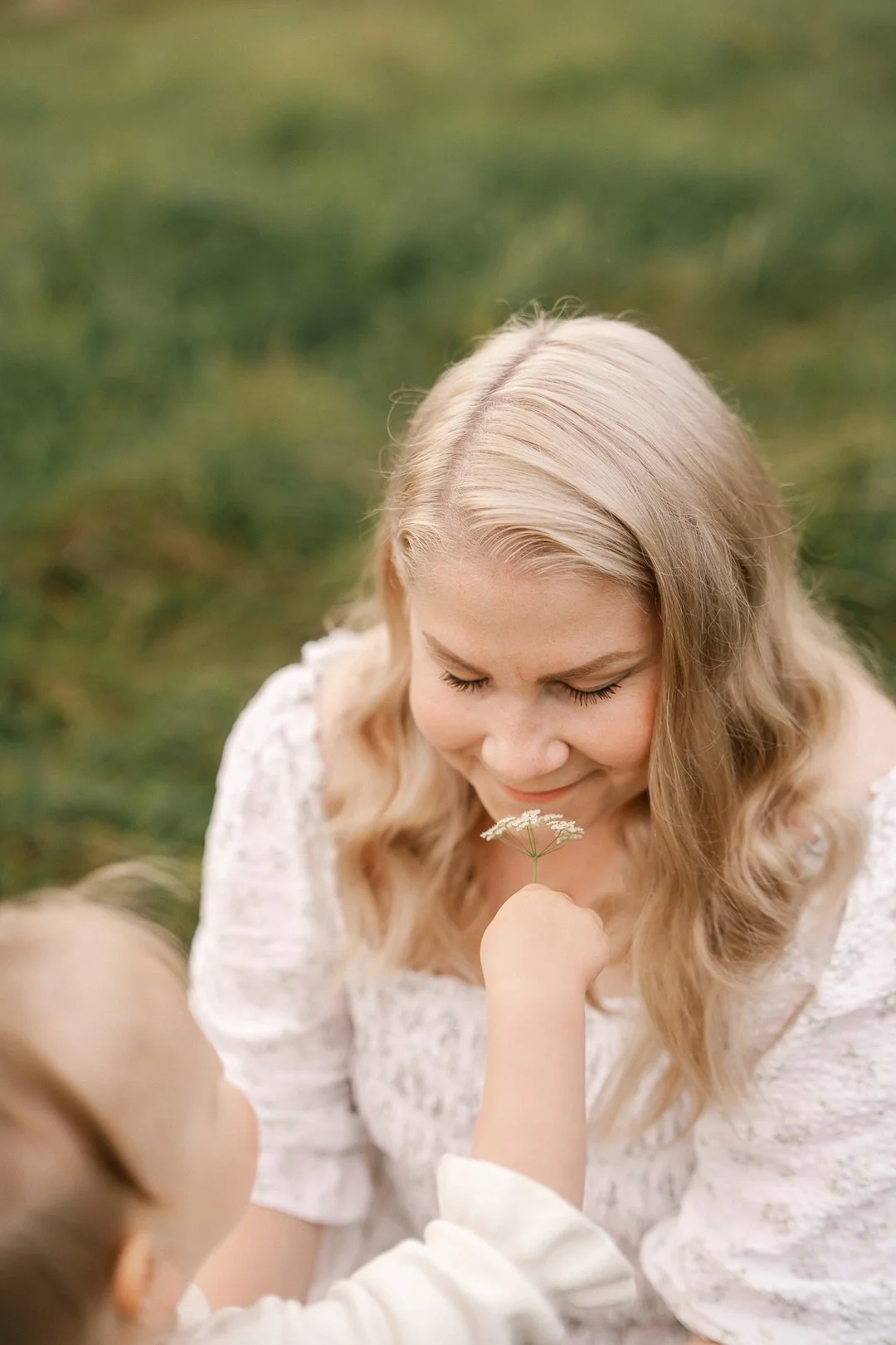 Nainen ja lapsi, lapsi antaa naiselle vihreän kasvin, maaseudulla, keväällä