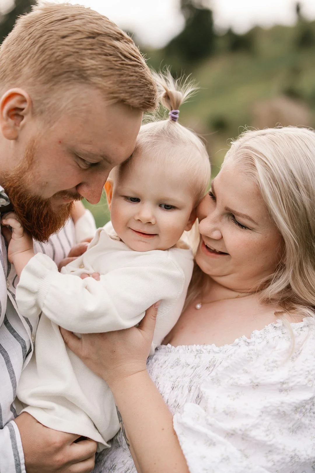 Perhe halailee ja katsoo rakkautta lasta, tausta luonnon ympäröimä.
