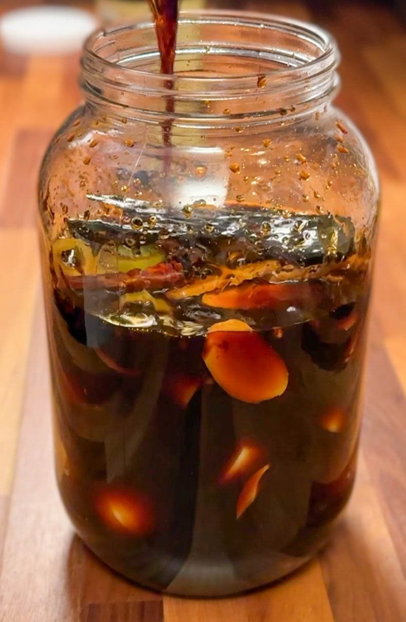 Adding soy sauce to raw ingredients in jar