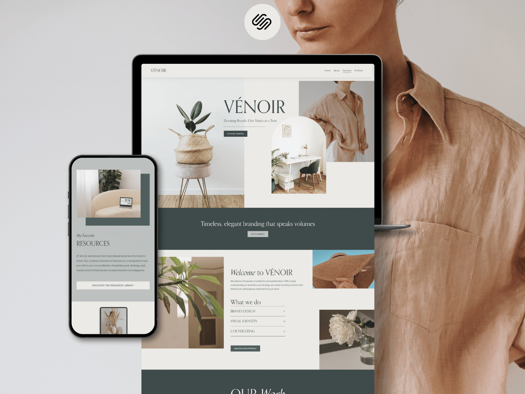A person standing next to a tablet and smartphone displaying a website with minimalist interior design and branding content for VÉNOIR, featuring images of home decor and plants.