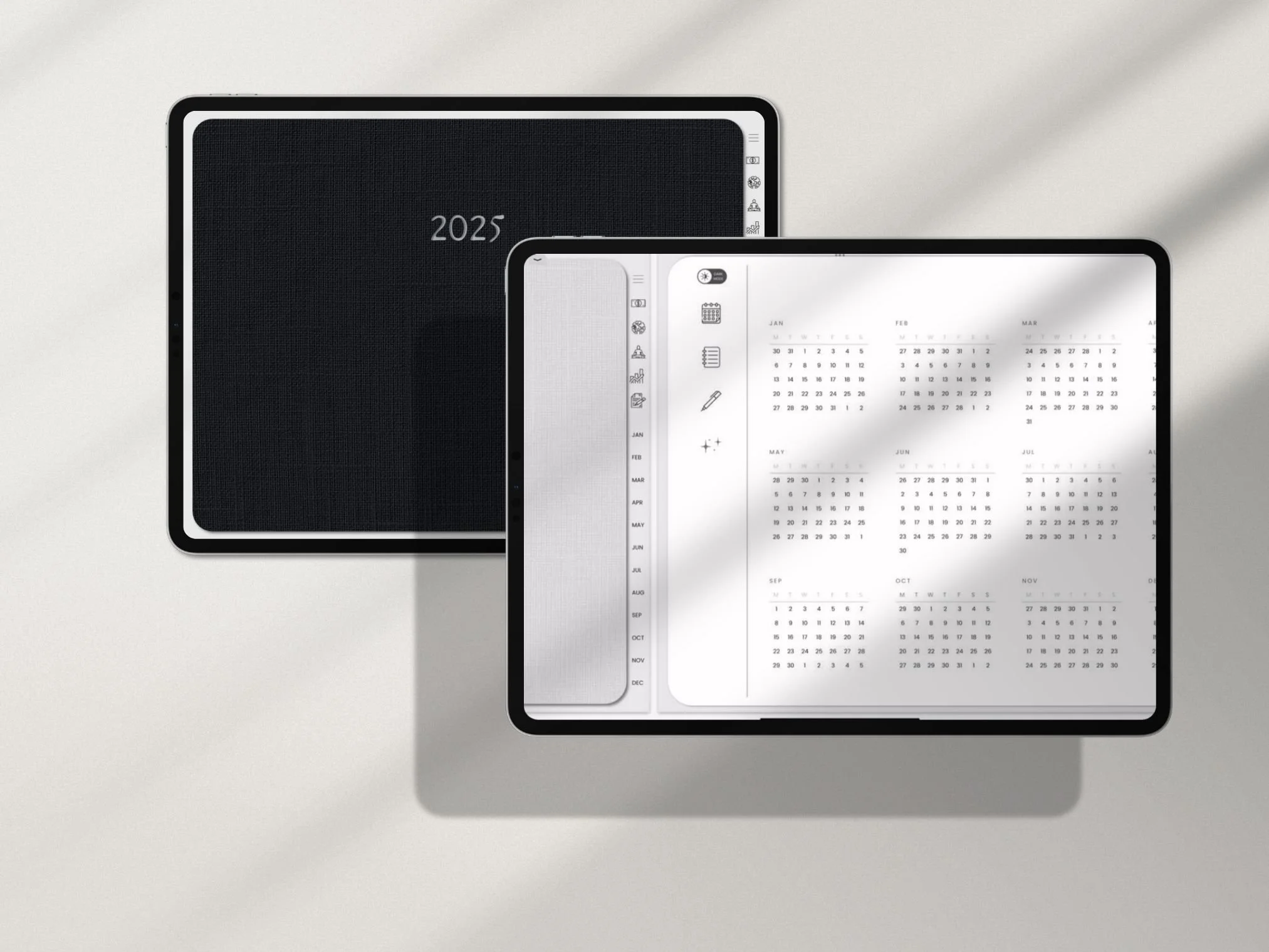 Two digital tablets on a white surface, one displaying a 2025 calendar and the other a yearly planner.