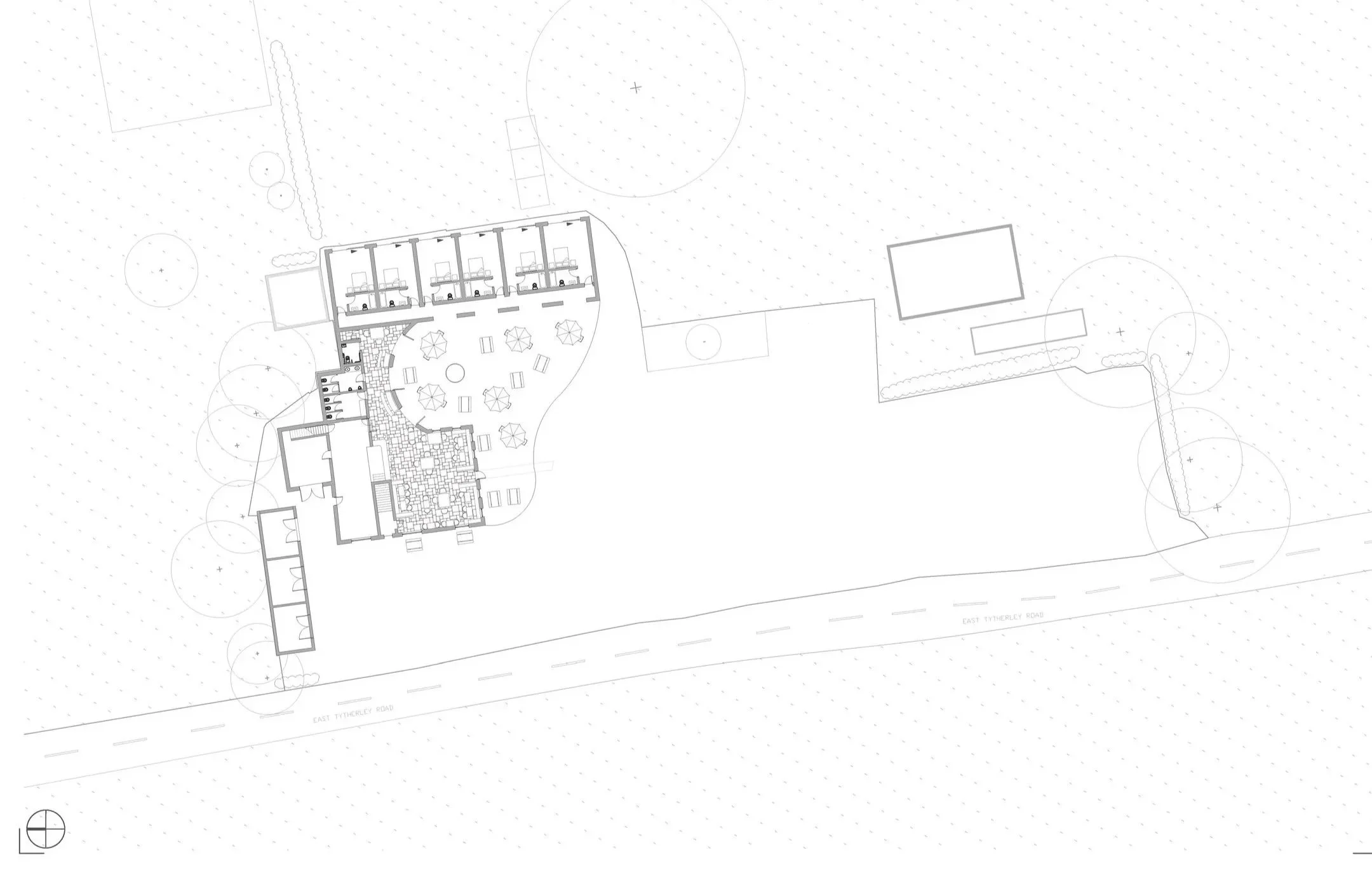 Architectural site plan of a building with indoor and outdoor areas, including a terrace with umbrellas, trees, and parking spaces along East Tytherley Road.