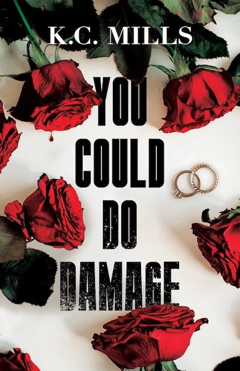 Book cover titled 'You Could Do Damage' by K.C. Mills, with red roses and wedding rings arranged on a white background.