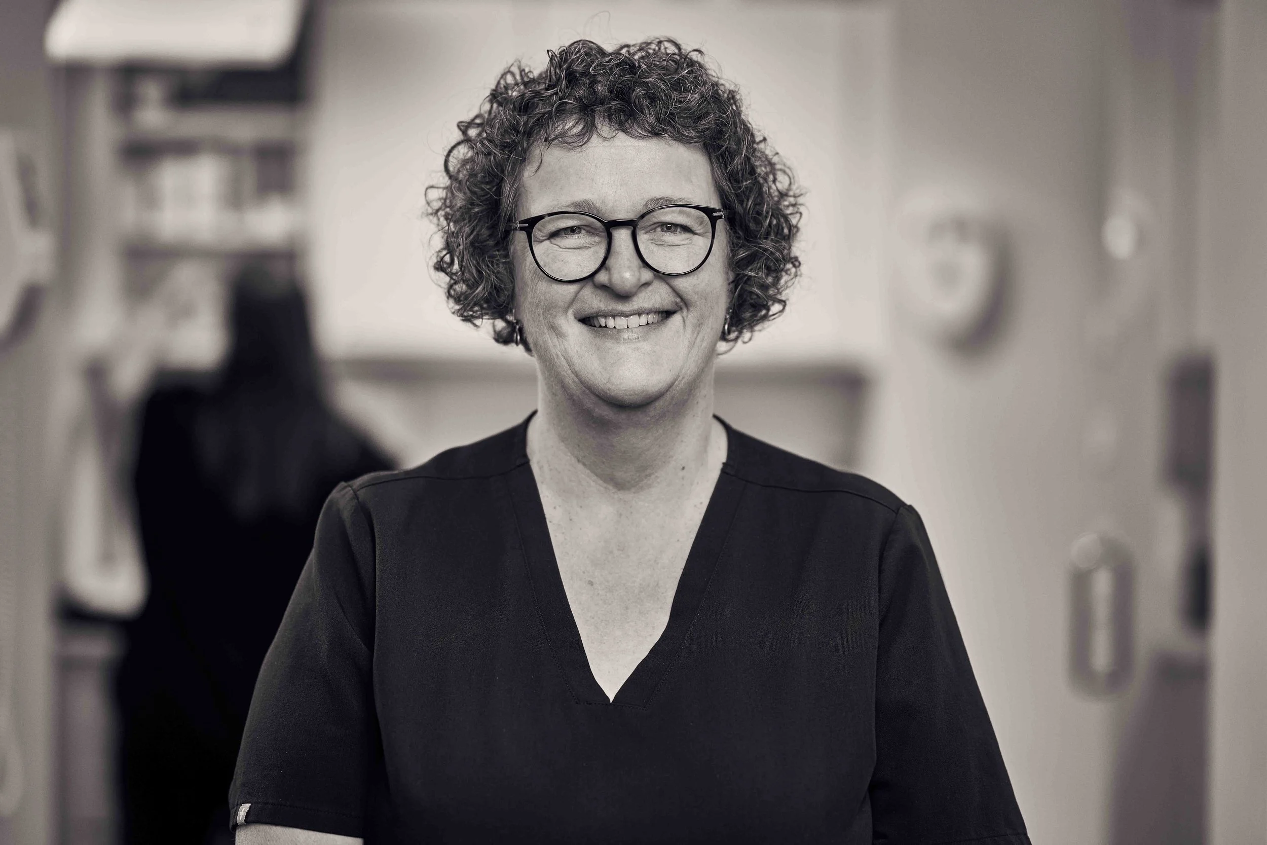 Smilende kvindelig sygeplejerske i sort uniform