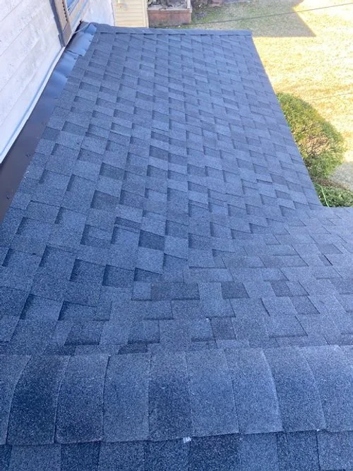 A close-up view of a dark gray asphalt shingle roof on a house.
