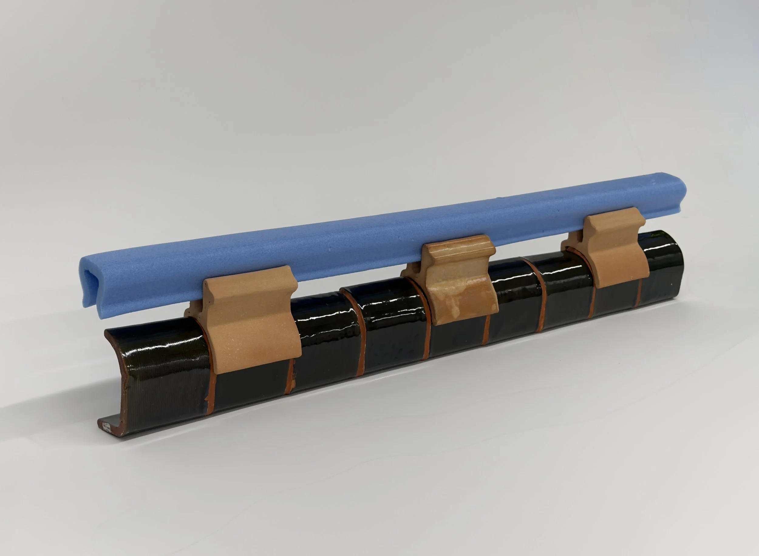 Uģis Albiņš, Blue foam edge protector, clay, glaze, 2026, blue foam edge protector, clay, glaze, 50 x 10 x 6cm.
