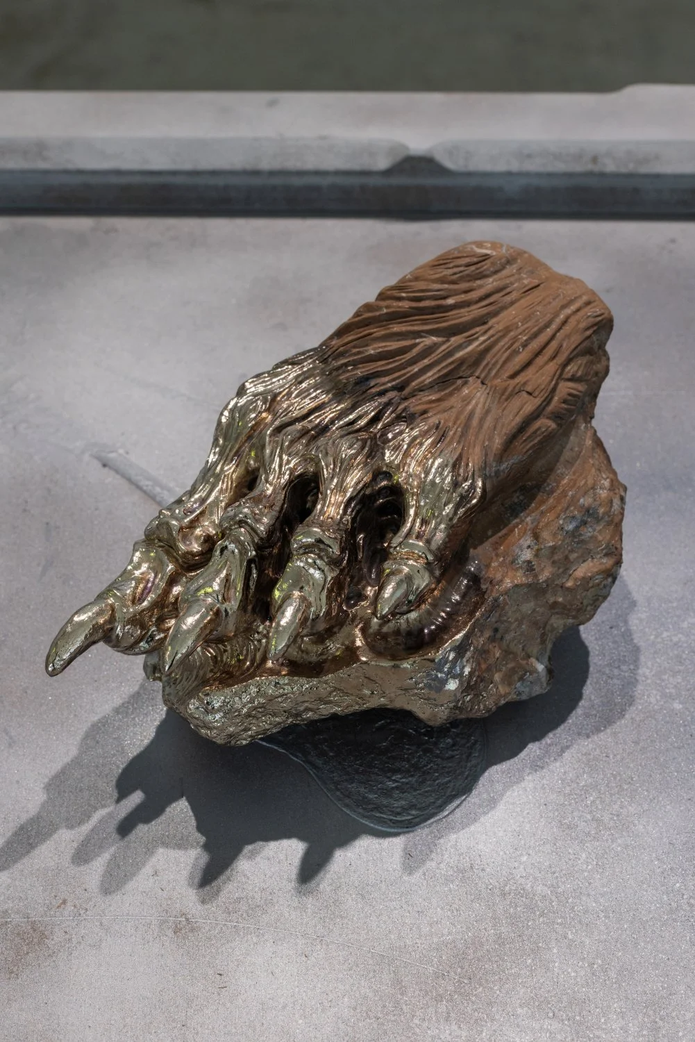 Darja Popolitova, Nails don’t lie, 2026, sculptural object, Estonian oil shale, chrome
laser engraving, silicone toe separator. Photo: Kristīne Madjare