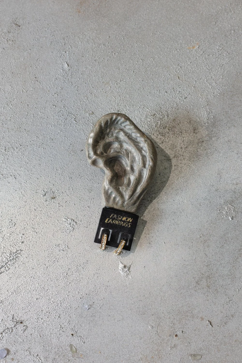 Darja Popolitova, Brooch, 2026, a piece of ancient Baltic limestone plateau, modern earrings, laser engraving, steel fasteners. Photo: Kristīne Madjare