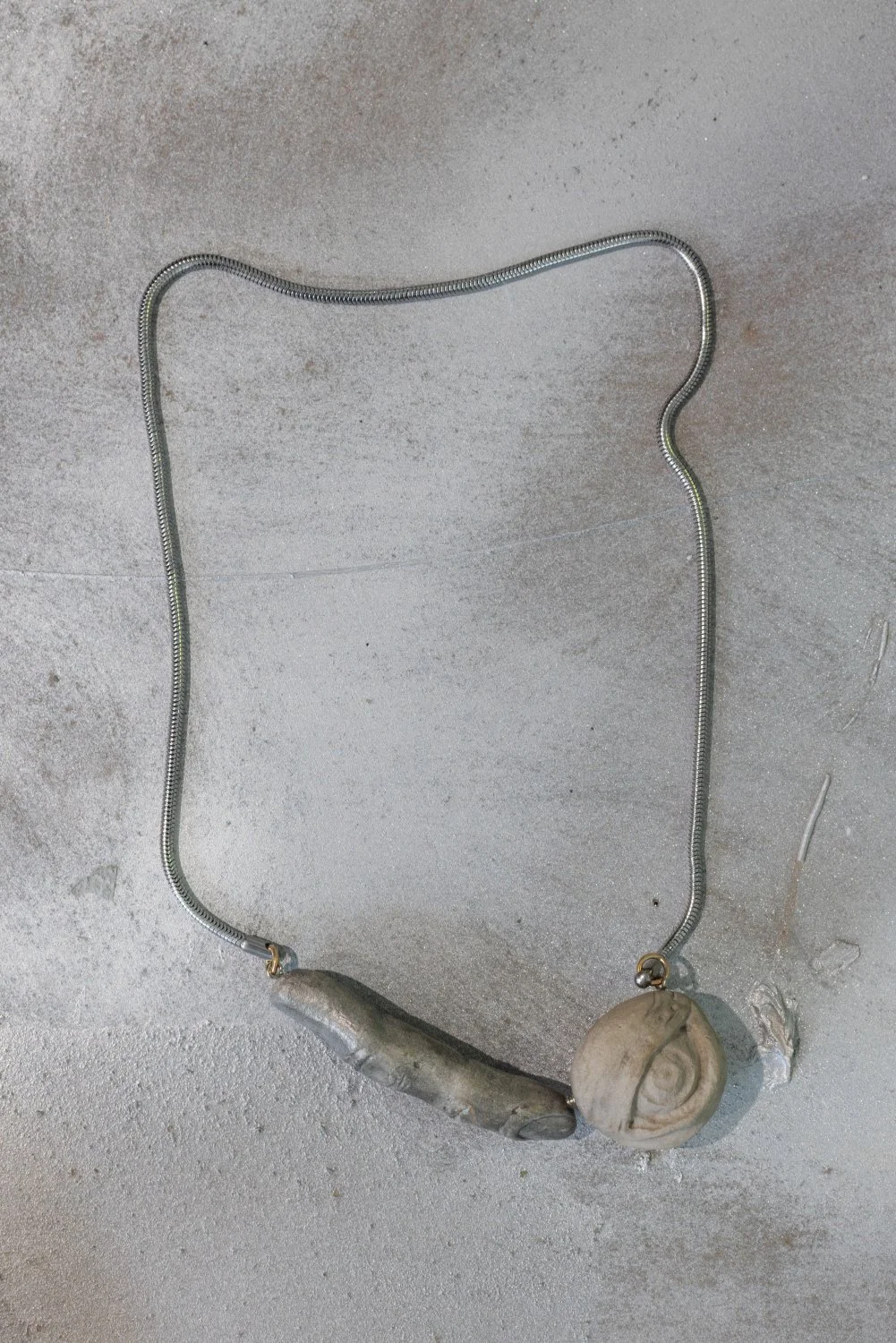 Darja Popolitova, Necklace, 2026, pieces of ancient Baltic limestone plateau, primitive shine, bayonet lock, laser engraving, silver steel chain, gold 14K. Photo: Kristīne Madjare