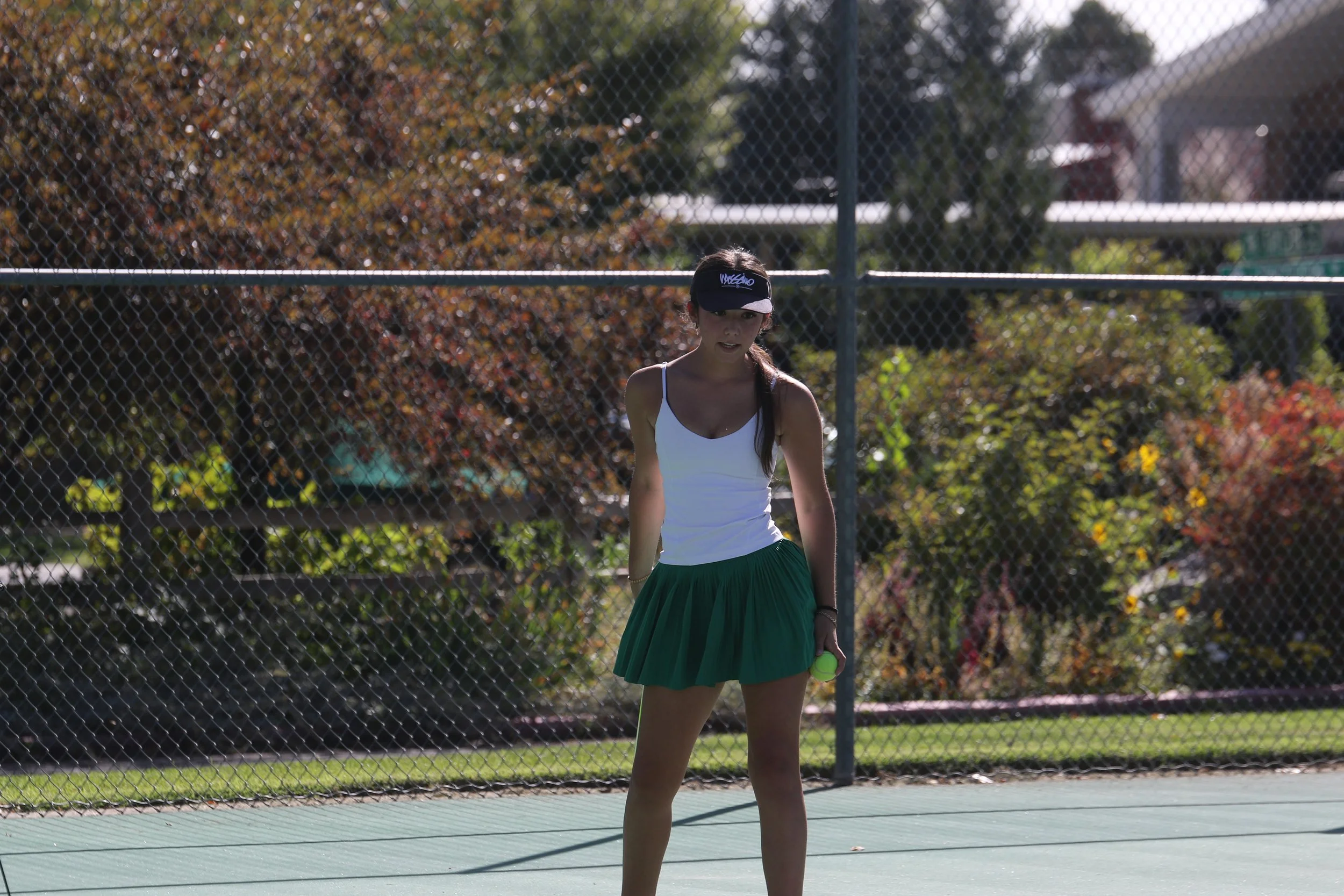 Female tennis player reaches out to hit the ball.