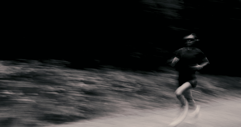Person running outdoors on a trail with motion blur