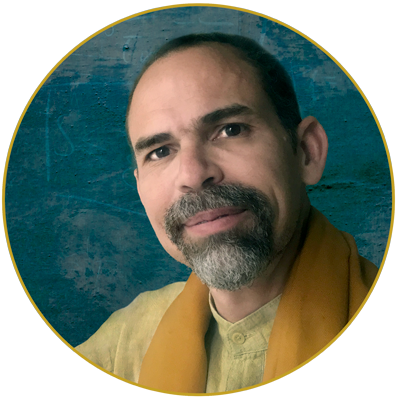 Foto de Nandikesha con fondo azul y camisa amarilla.