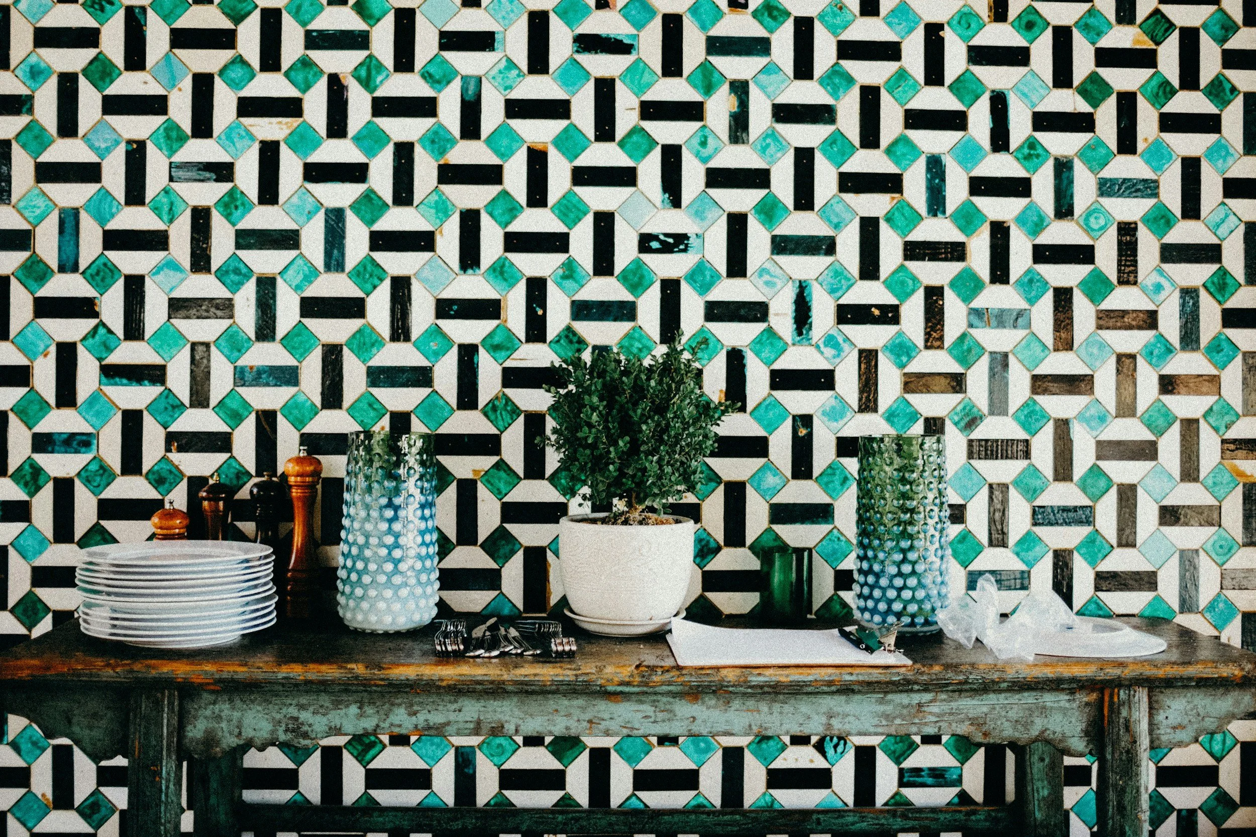 Dining room design in Austin with rustic wood table and colorful geometric tile backsplash  curated by Larisa Naomi Interiors