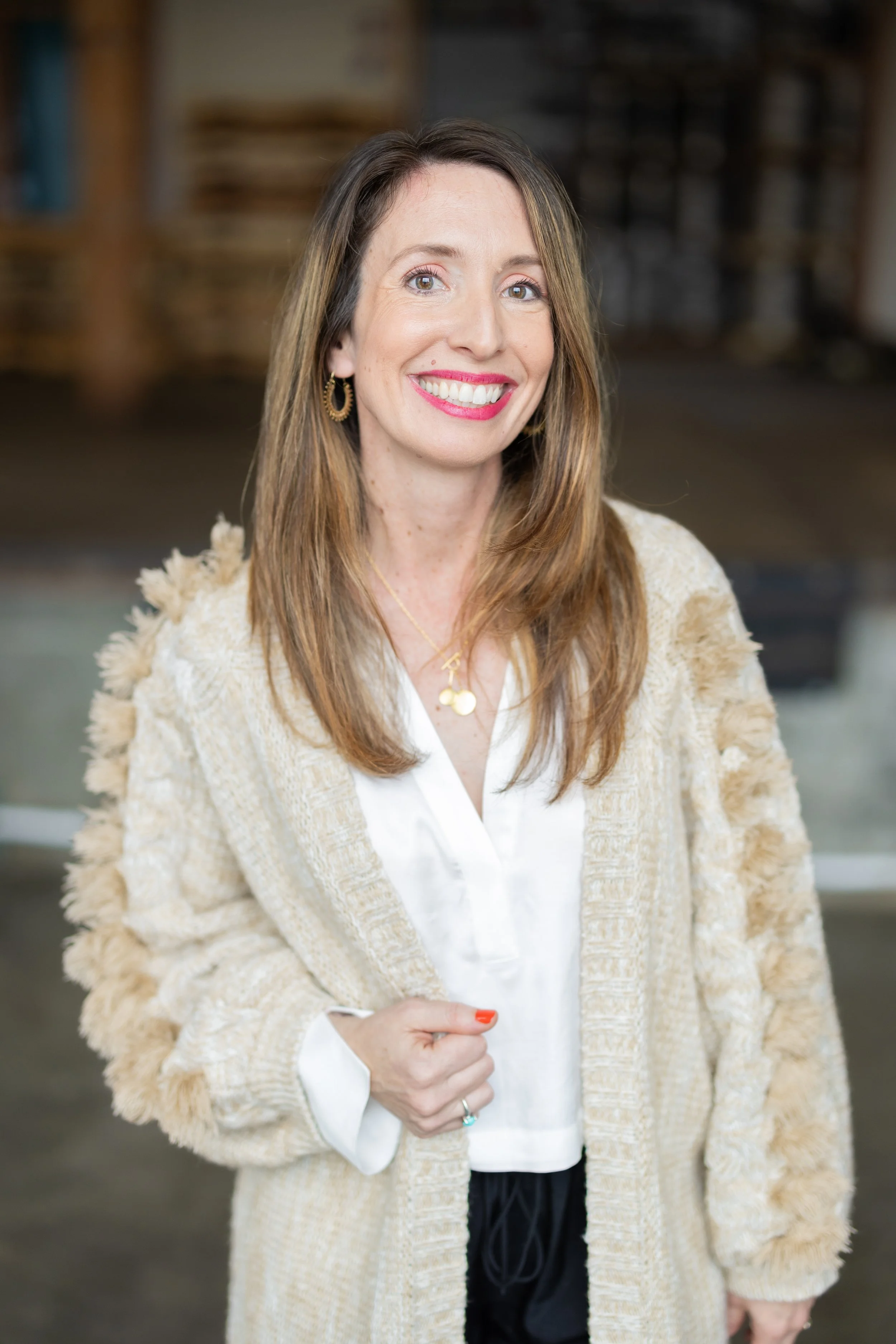 Interior designer portrait with warm, rustic background – natural brand photo with cream sweater and red lipstick