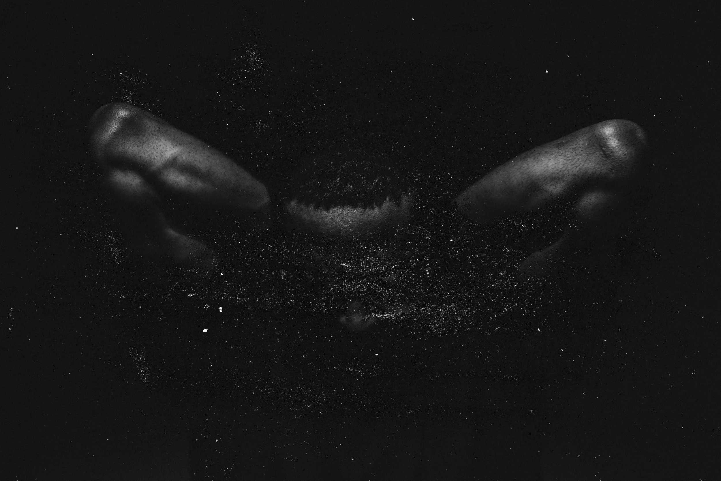 Schwarze-Weiß-Fotografie. Zwei Arme sind mit den Ellbogen nach Oben gestreckt, darüber eine Starke Textur, im Mittelpunkt ist eine verschwommene Gesichtssilhouette.