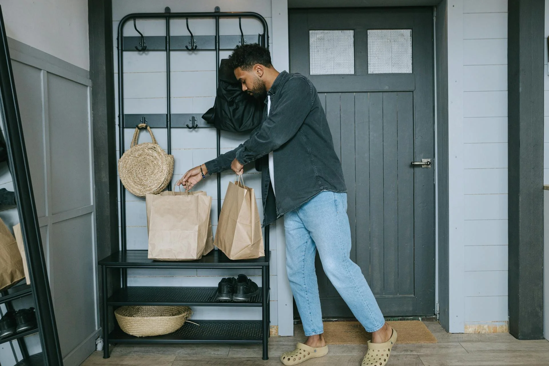 Man putting paper bags on shelving system in mudroom