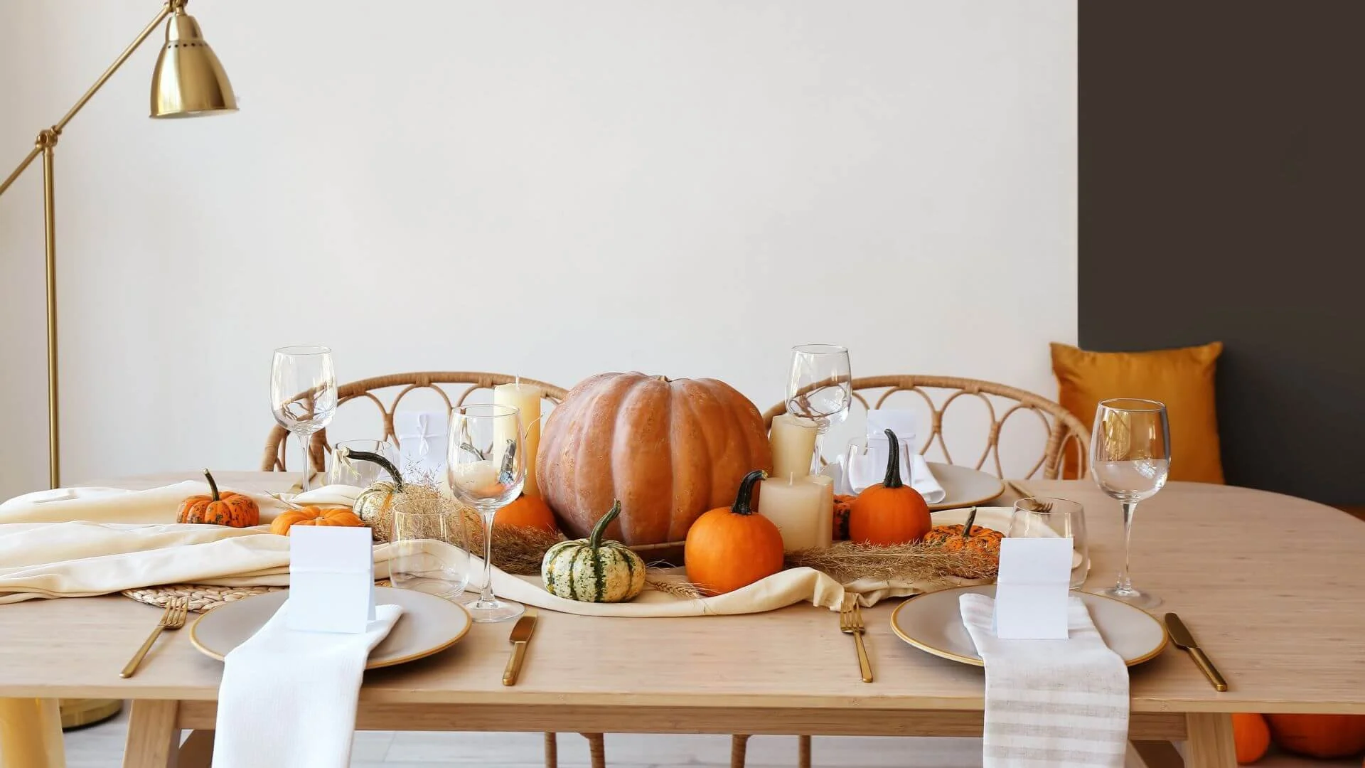 simple thanksgiving table with pumpkins and plates