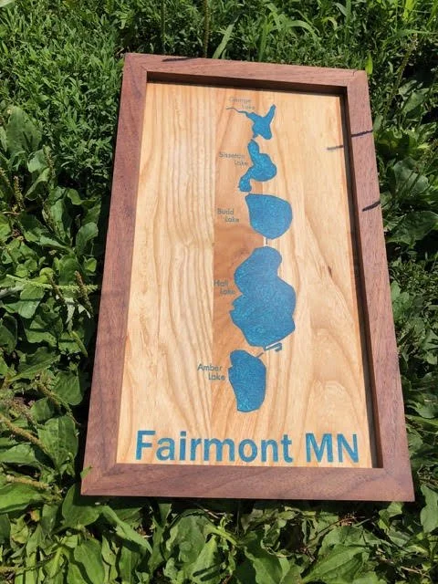 Handcrafted wooden lake map sign featuring Fairmont, Minnesota's five lakes with blue lake inlays and a dark wood frame.