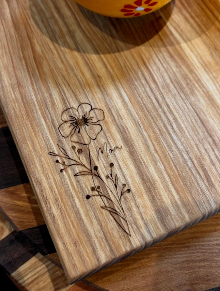 wooden cutting board with "mom" engraved on it