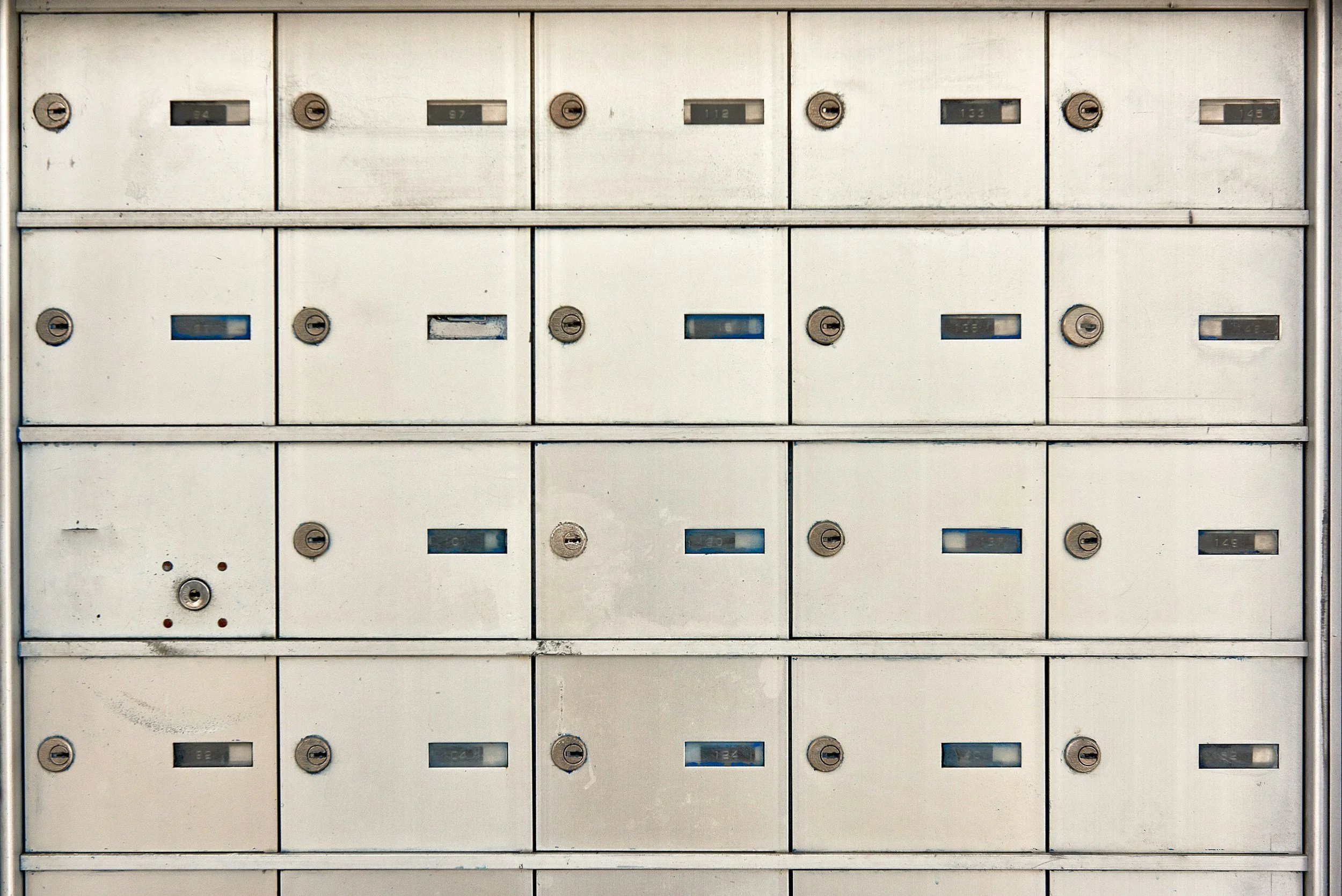 A wall of metal mailboxes with combination locks.