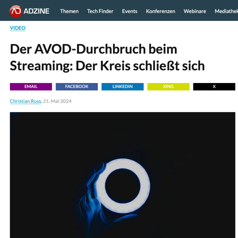 Eine Hand hält ein leuchtendes, kreisförmiges Objekt vor schwarzem Hintergrund.