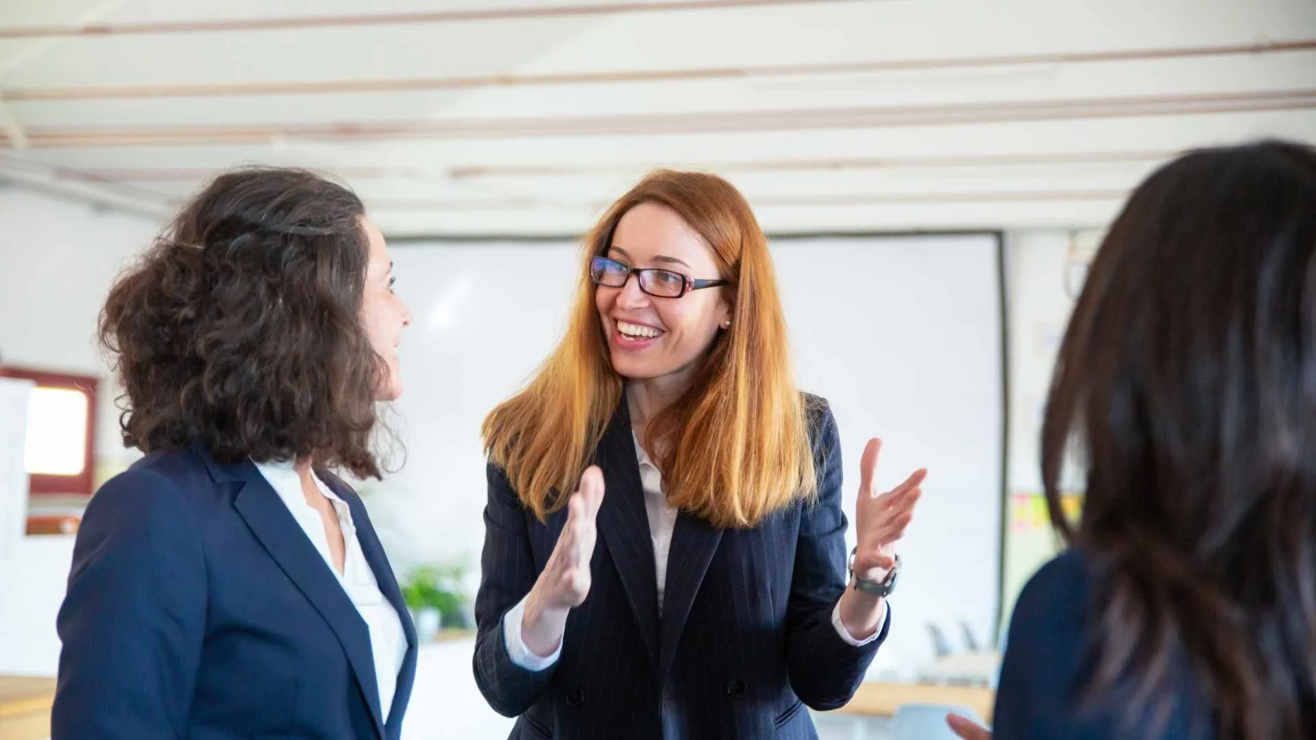 woman with red hair interacts with colleauges