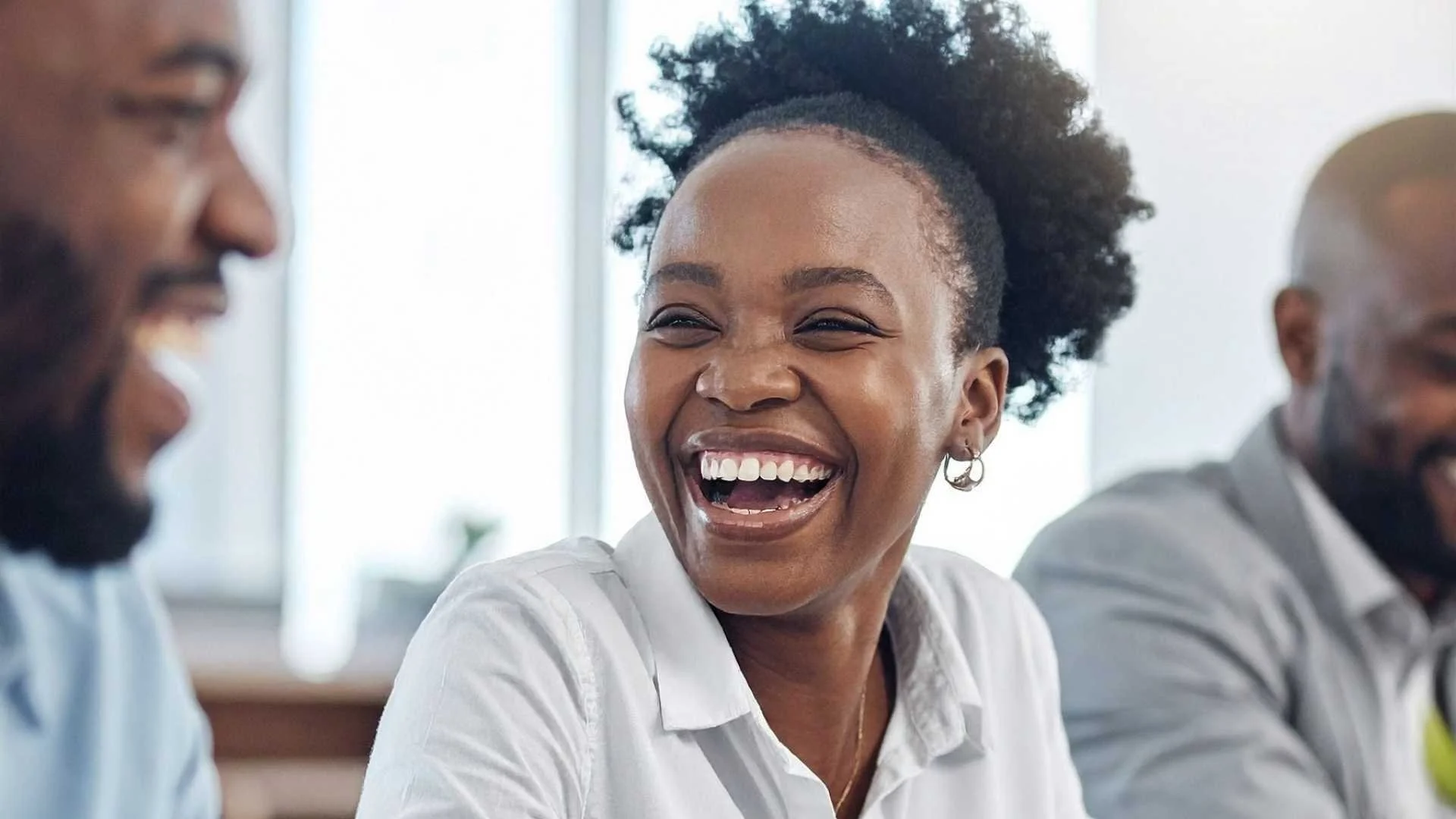 black woman smiles with colleagues