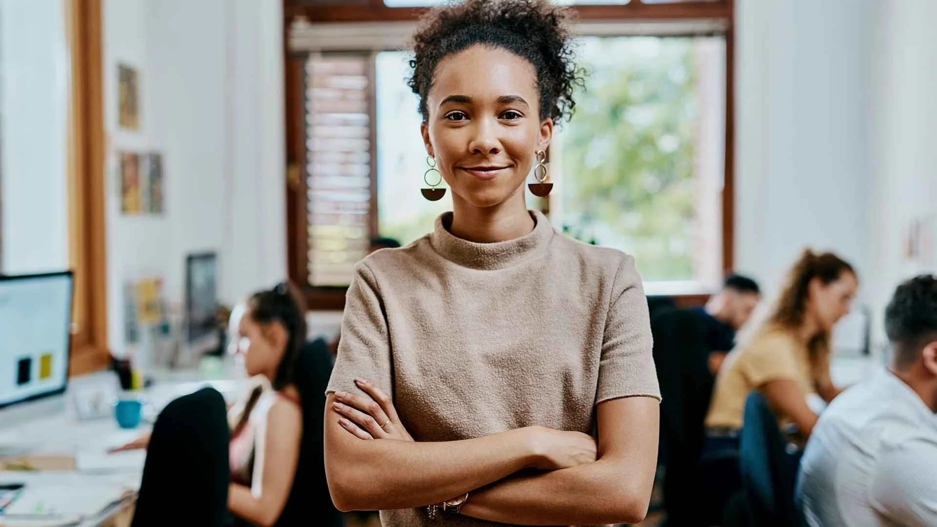 woman in tan sweater with arms crossed