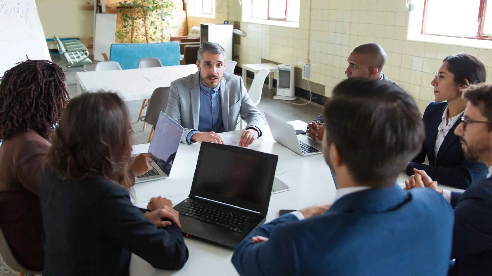man in suit leads executive team at work