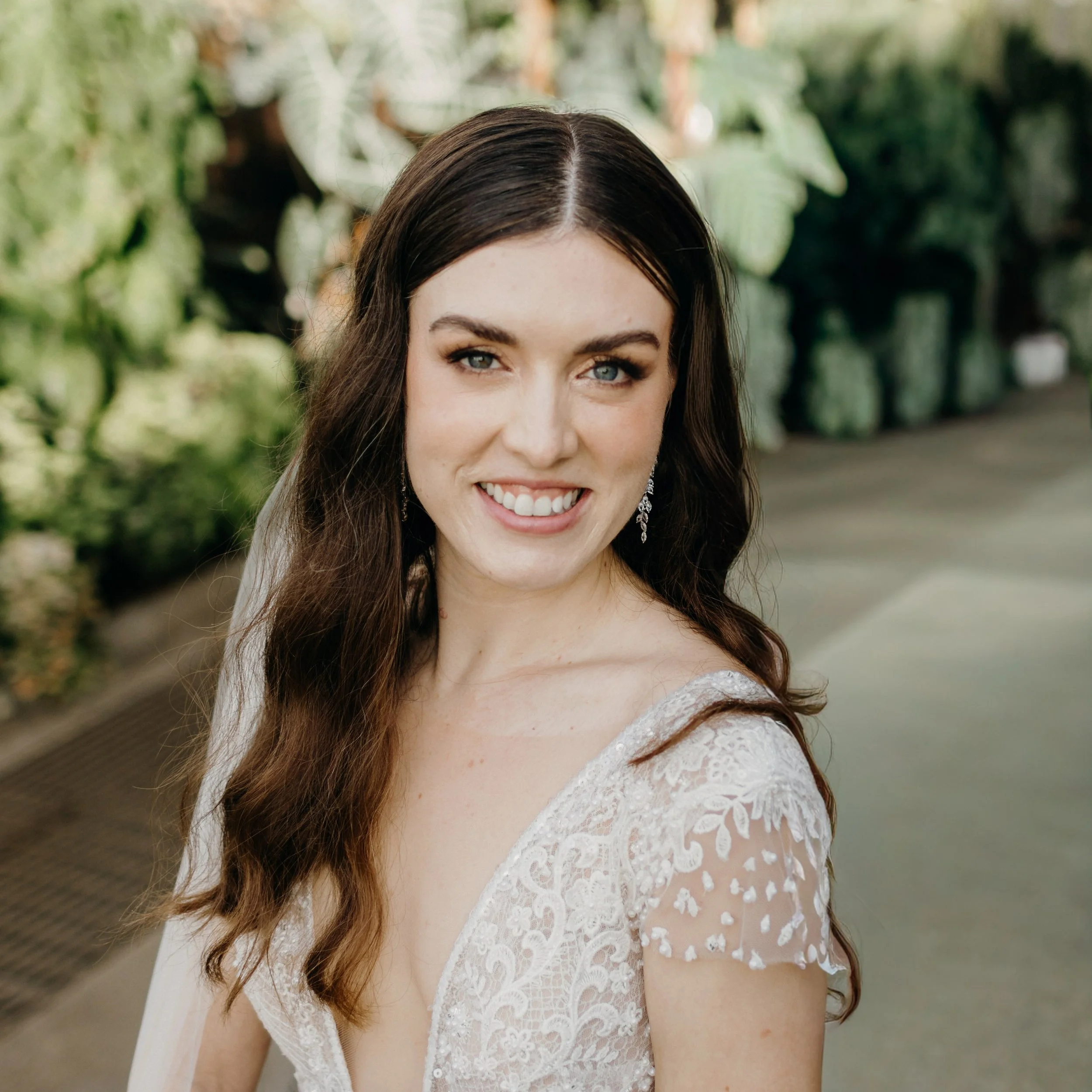Bride with soft glam makeup enhancing natural green eyes and radiant skin for a wedding look.
