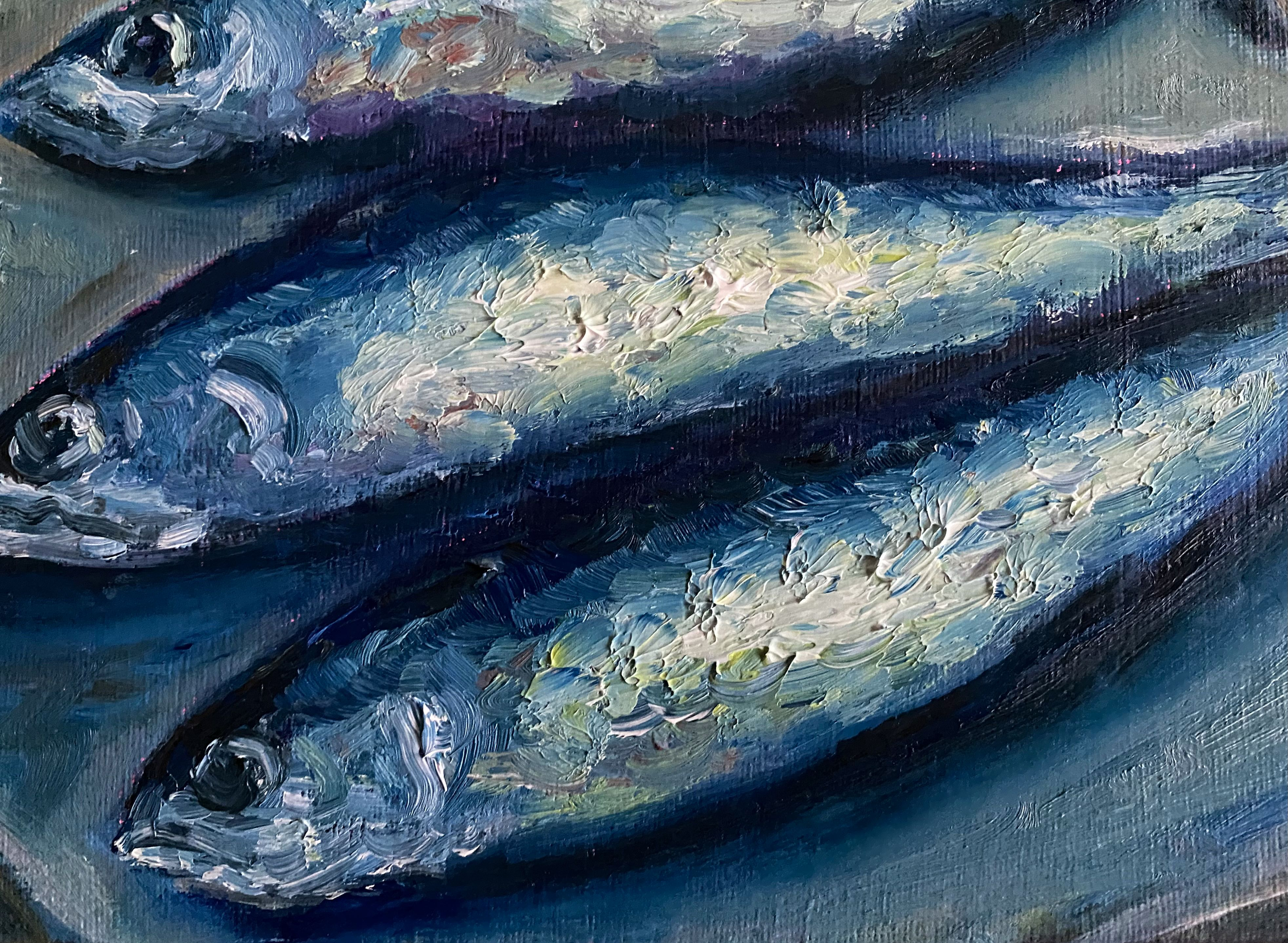 three silver blue sardines on light background