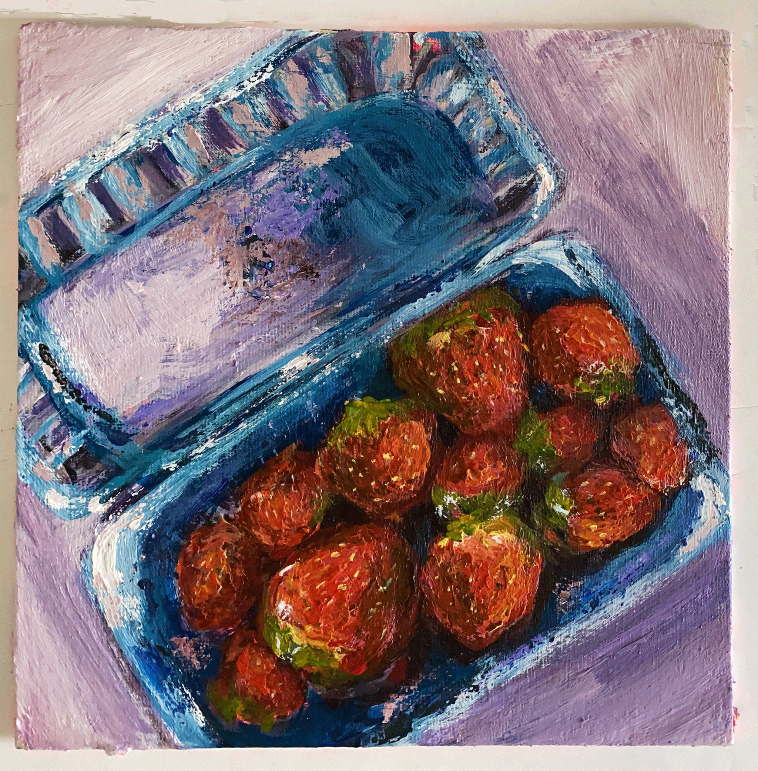 box of strawberries on lilac background