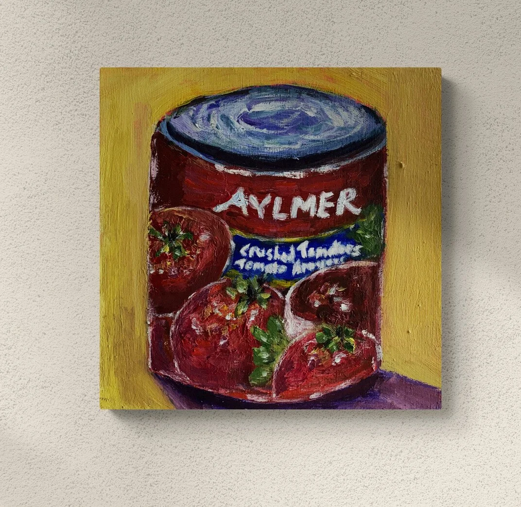 half opened red can of crushed tomatoes with white lettering on yellow background framed hung on wall.jpg