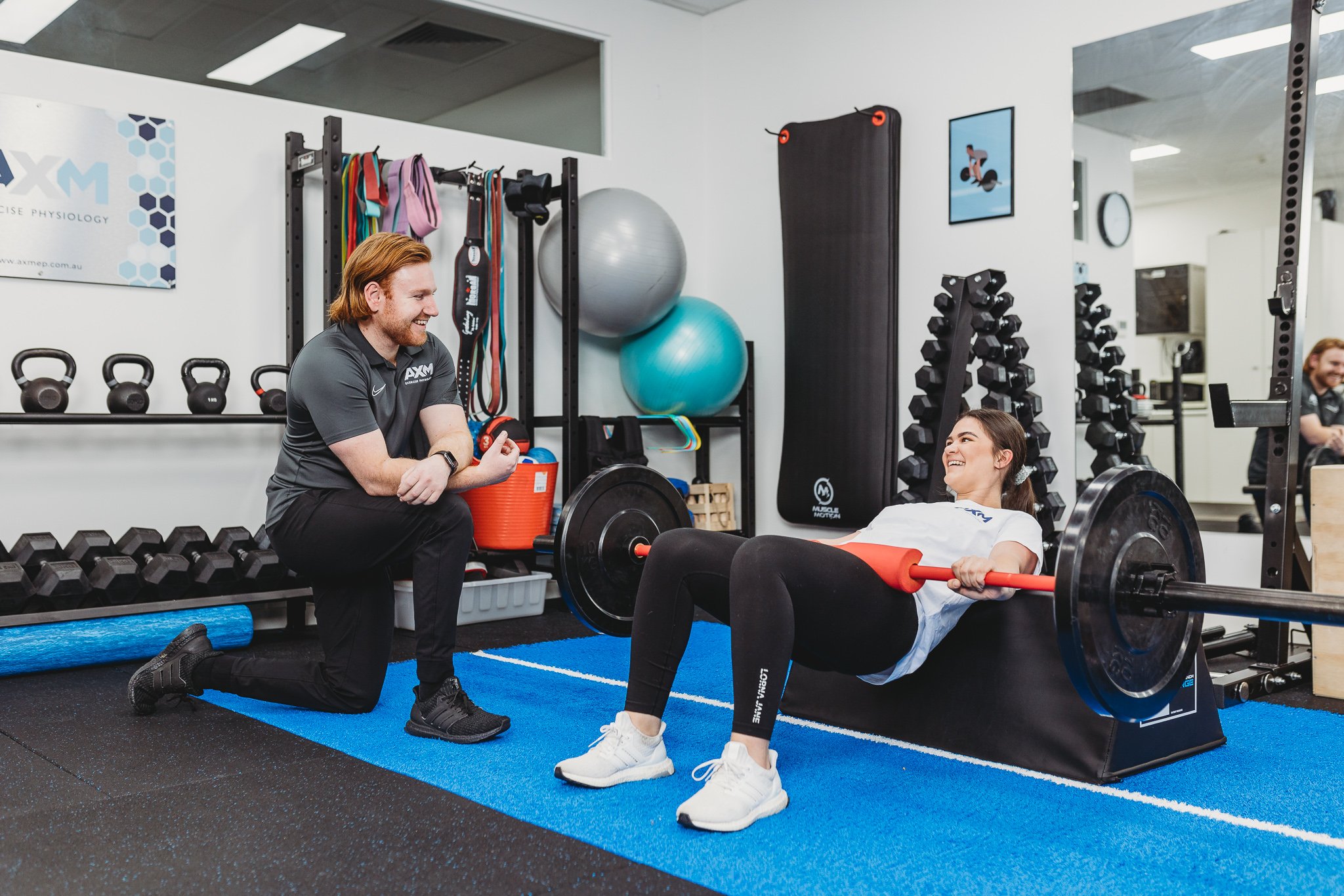Canberra Branding Photographer - trainer assists client in gym