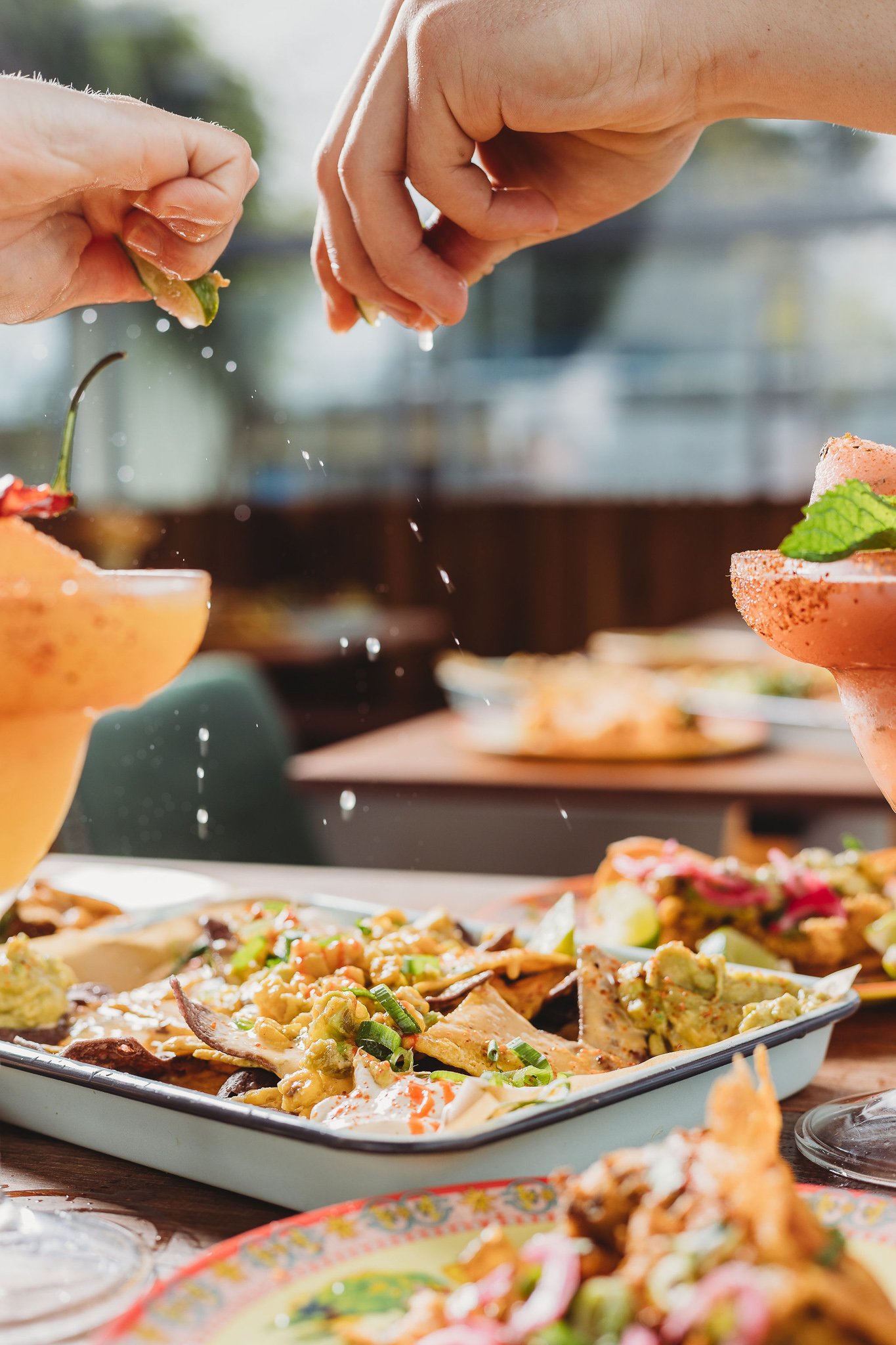 Canberra food photographer - hand squeezes lime on nachos