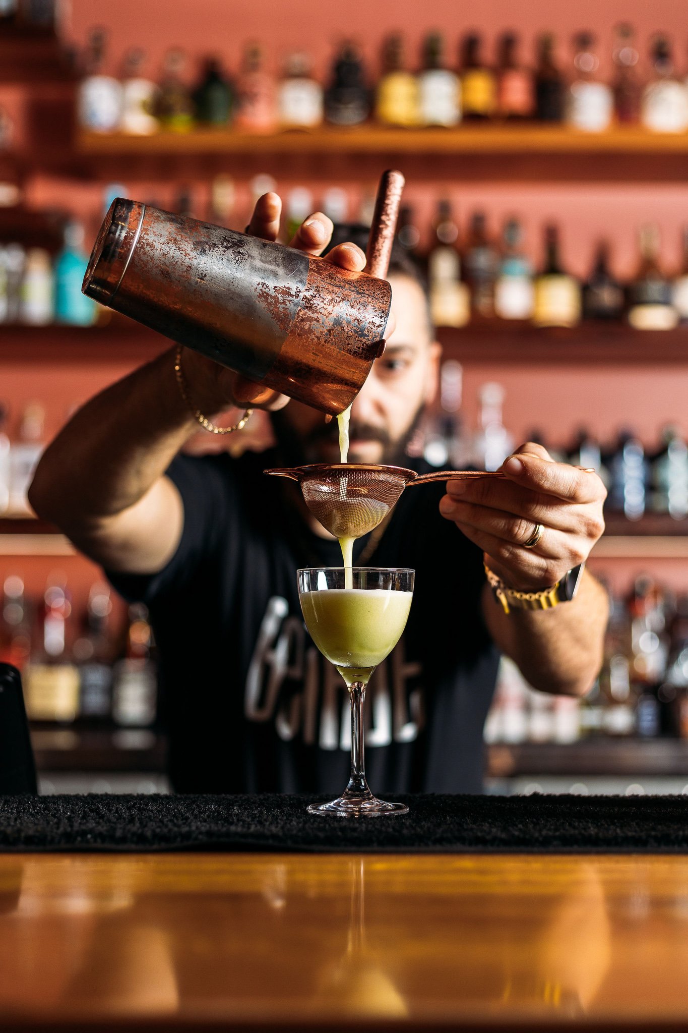 Canberra food photographer - bartender pours cocktail