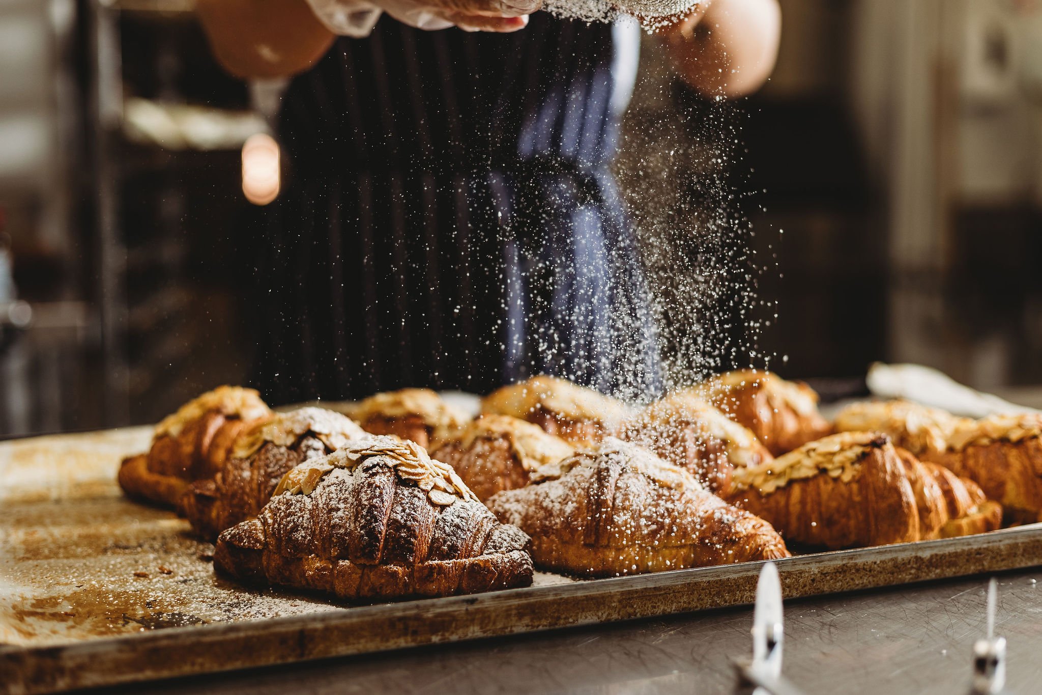 Canberra food photographer - dusting icing onto croissants