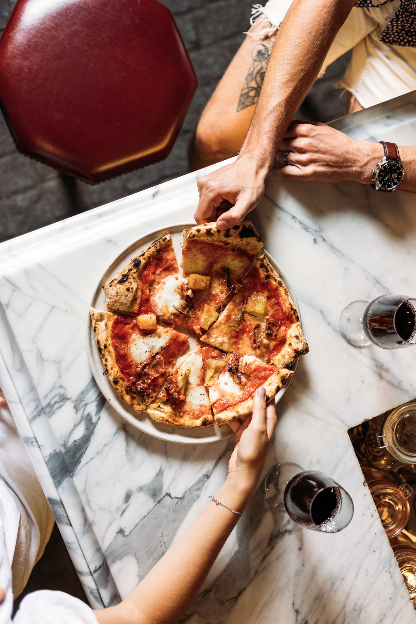 Canberra food photography - hands pulling pizza slices